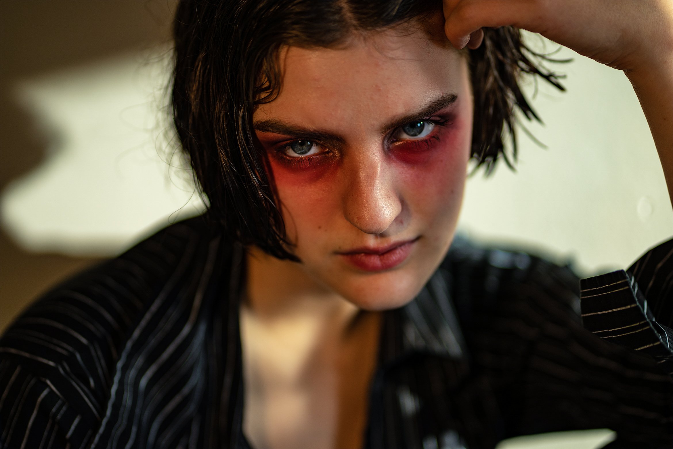 Close up portrait of a model. Blue eyes. Red eyeshadow with glitter. Editorial look. Natural Lighting. Shot with Sony A7II. New York