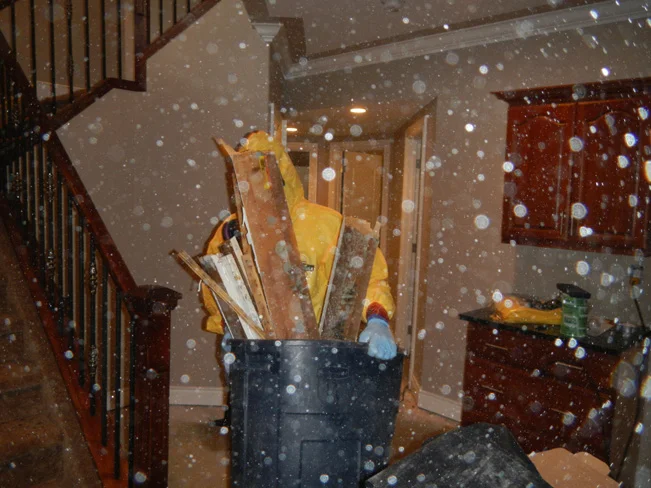 White particles of dust containing mold and fentanyl float through the air while the team at Mayken clean out the home. 