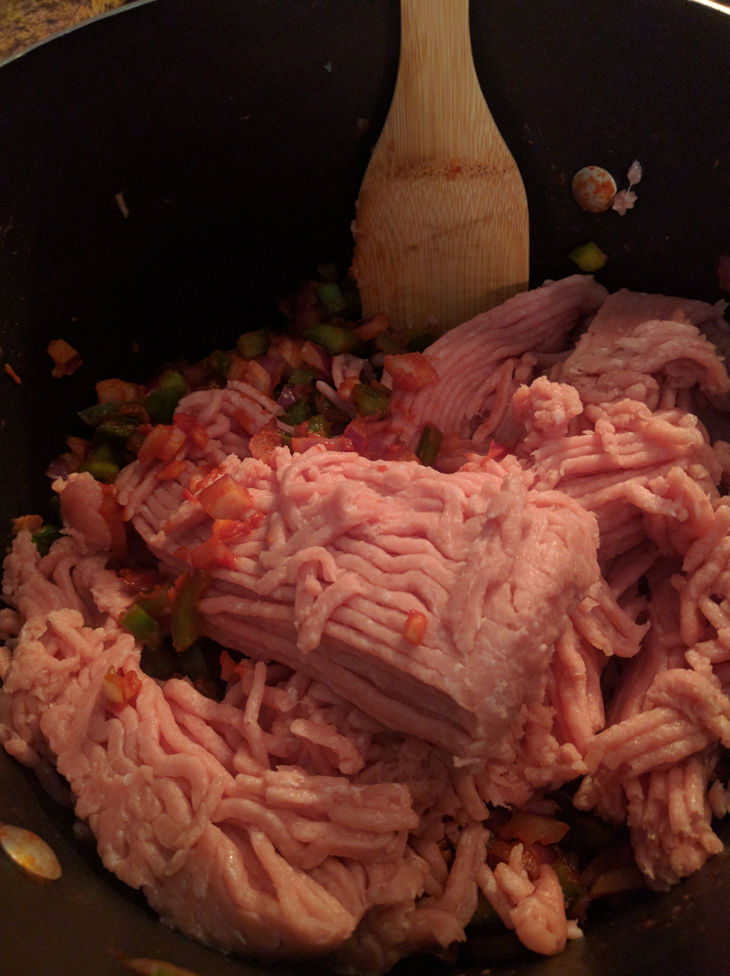 Mixing in the ground turkey with the veggies, tomato paste, and garlic.