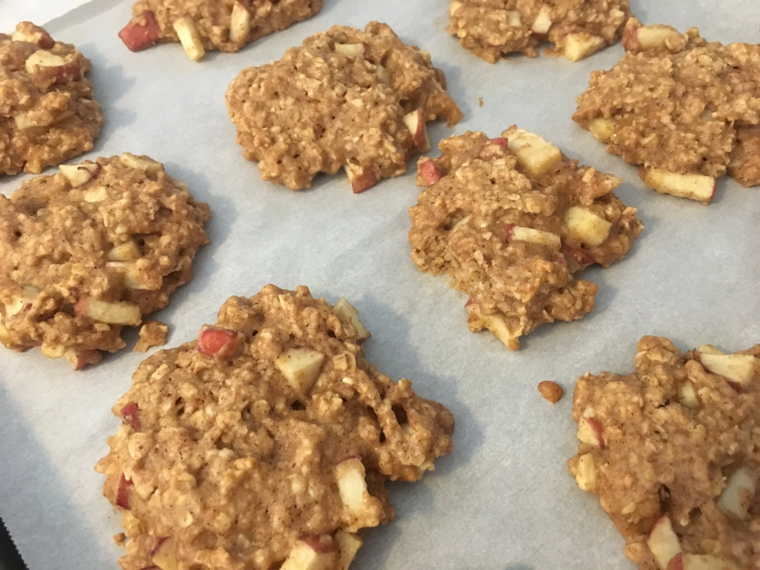 Cookies cooling off on the baking sheet before further cooling off on a wire rack.