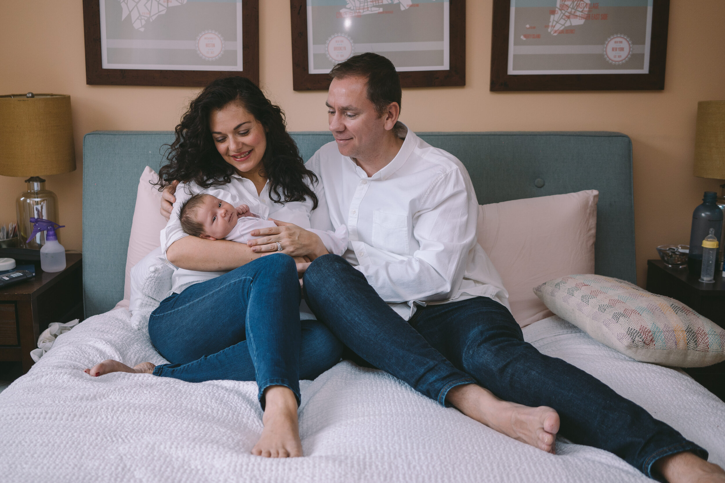 mom-and-dad-sitting-on-the-bed-with-their-newborn.jpg
