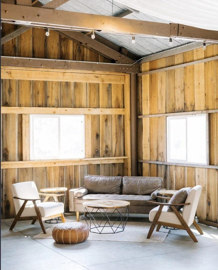 Soft light, warm wood, and curated lounge seating create the perfect blend of comfort and style inside the barn.