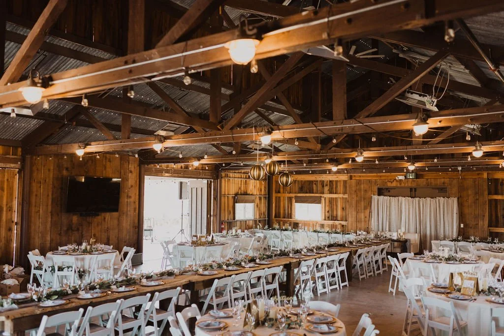 A room set for celebration &mdash; warm wood, glowing lights, and tables waiting for stories, speeches, and a very full dance floor ✨