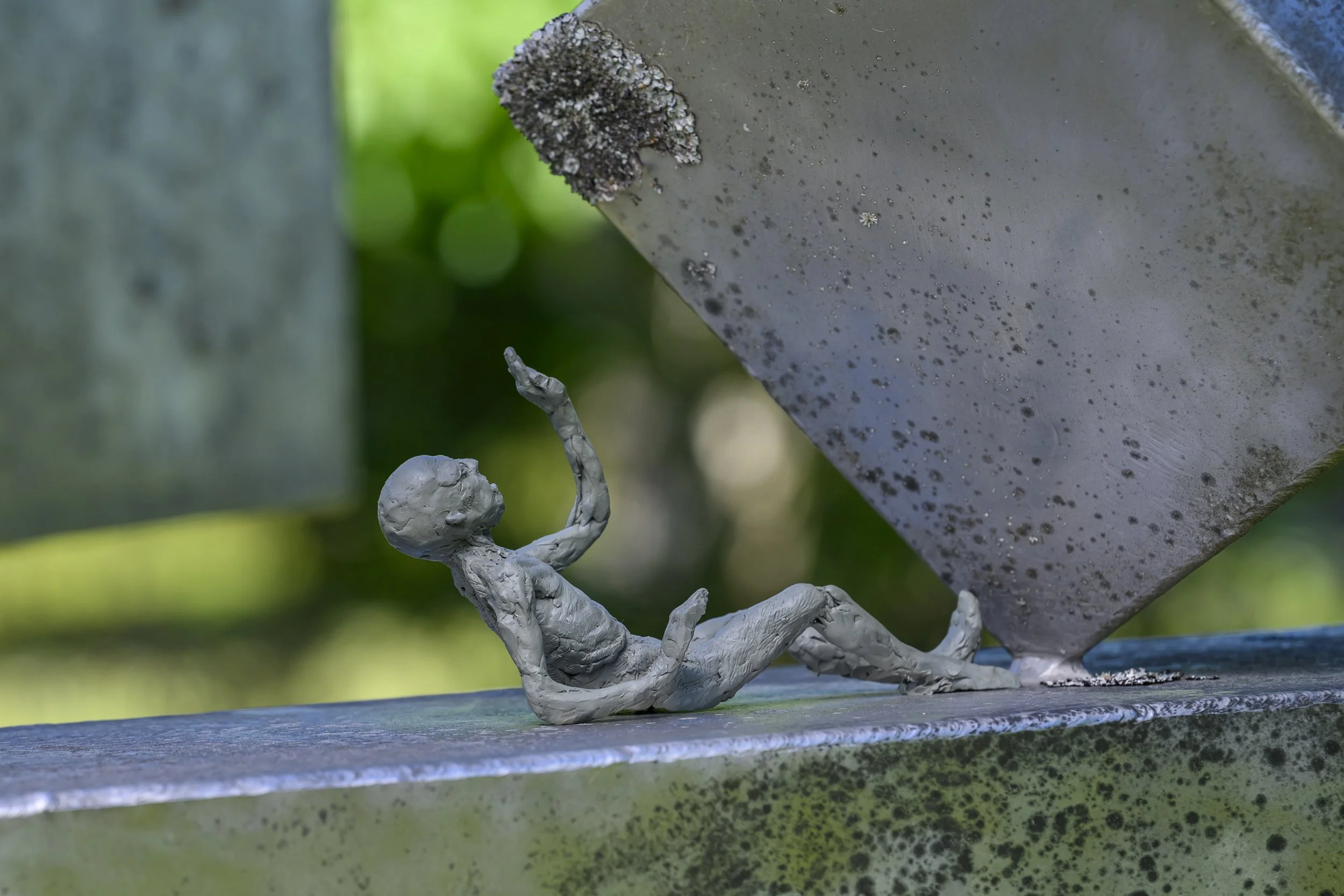 Clay figure near steel sculpture