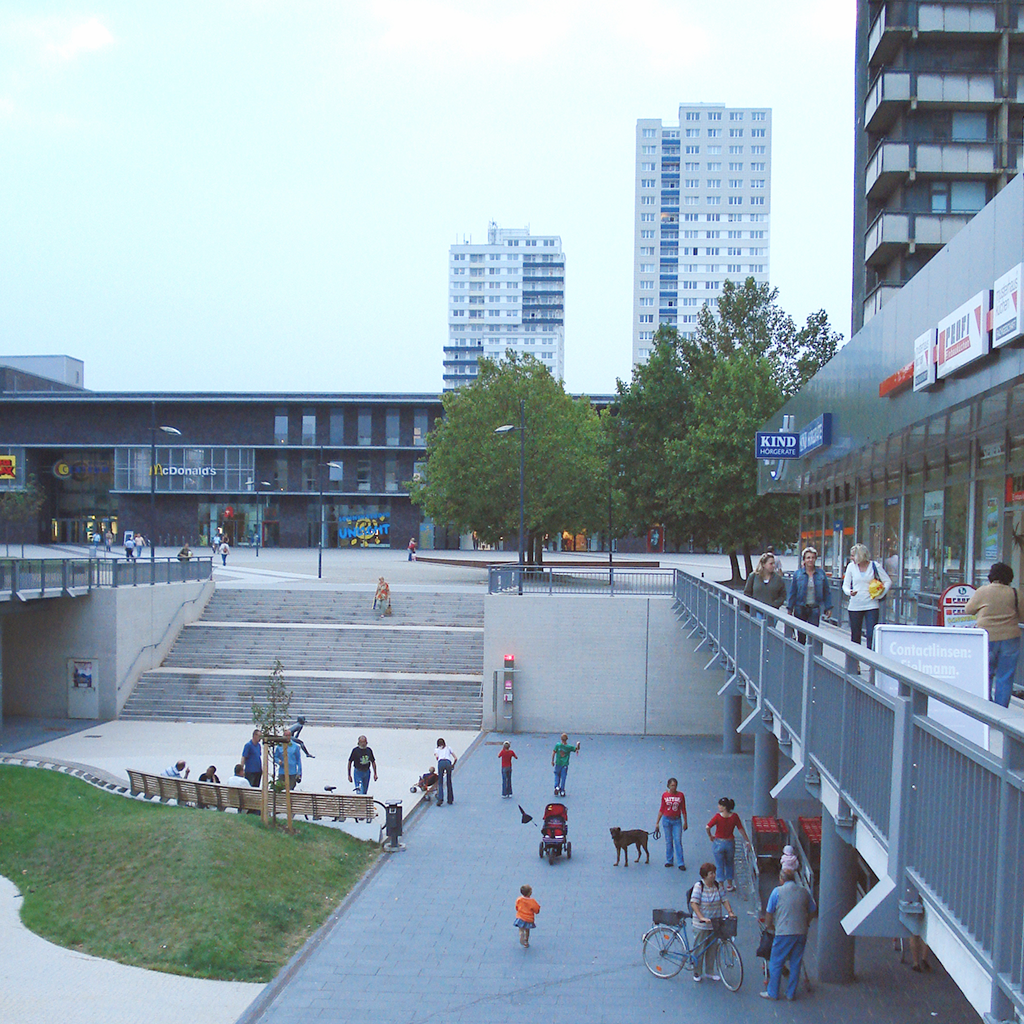  A public square and raised commercial promenade create draws for people to visit a space. Either way, care for the public realm creates spaces for people to gather.&nbsp;  Halle Neustadt, Germany 