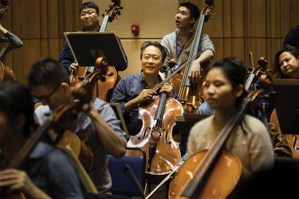 Yo-Yo Ma sits in the back of the cello section during orchestra rehearsal at YMCG. Photo by Li Lewei
