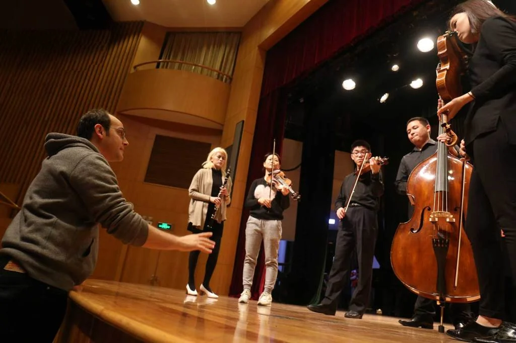 Cellist Mike Block coaches a chamber group before a YMCG “Tomorrow Concert.” Photo by Liang Yan