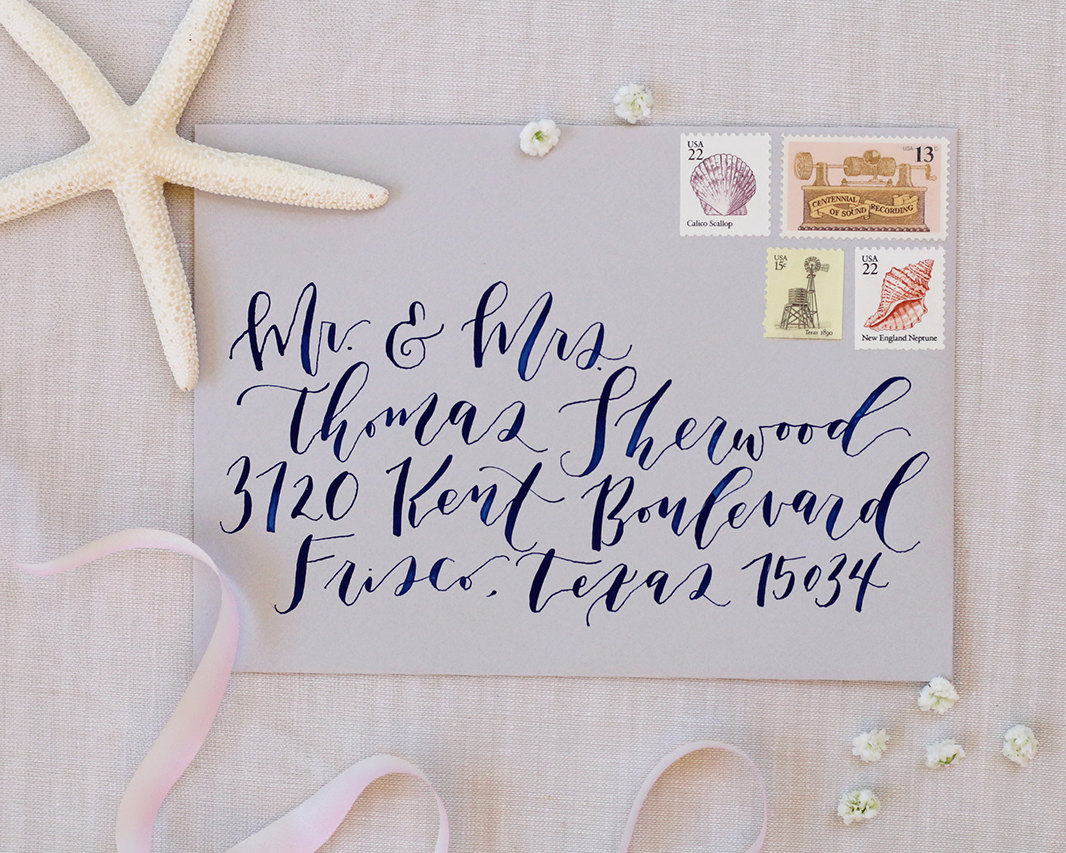 Gorgeous outer envelope for formal Cabo wedding with navy blue calligraphy and vintage stamps