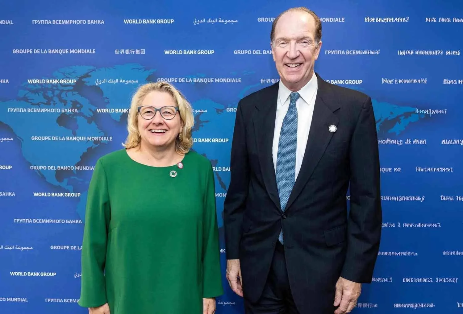 A delegate posing for a photo with former World Bank President David Malpass at an international finance summit in Los Angeles.