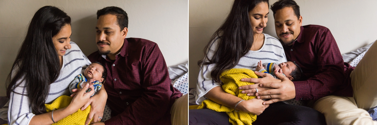 Parents holding their baby on a bed