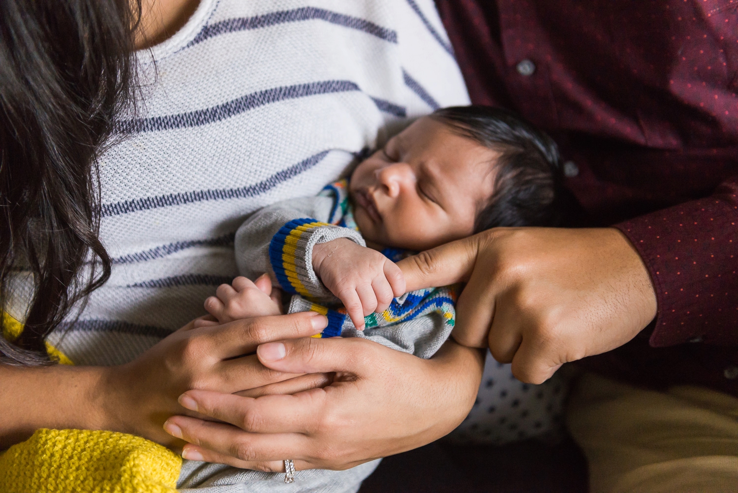 Baby holding his father's finger
