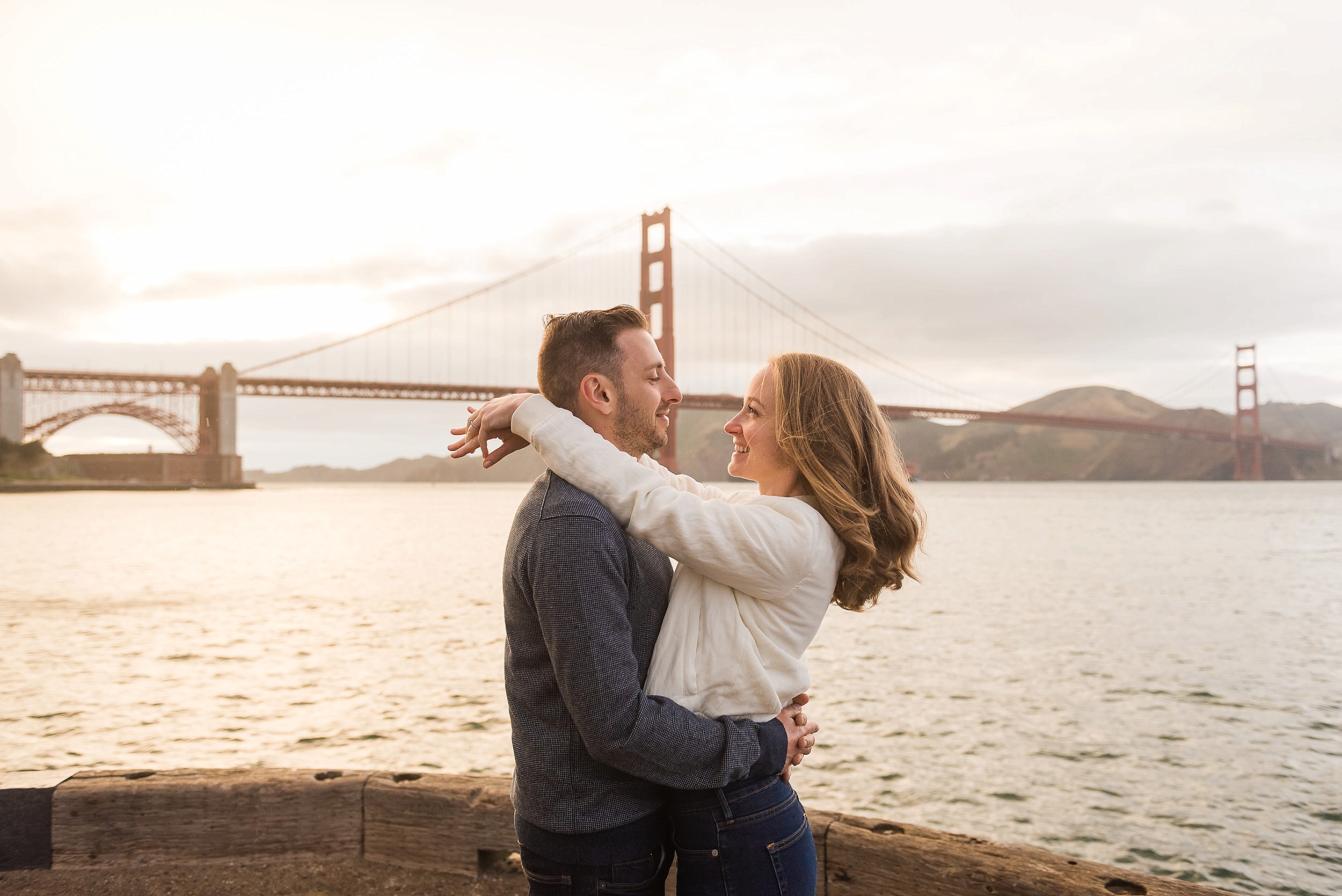 Couple laughing in front of the Golden Gate Bridge