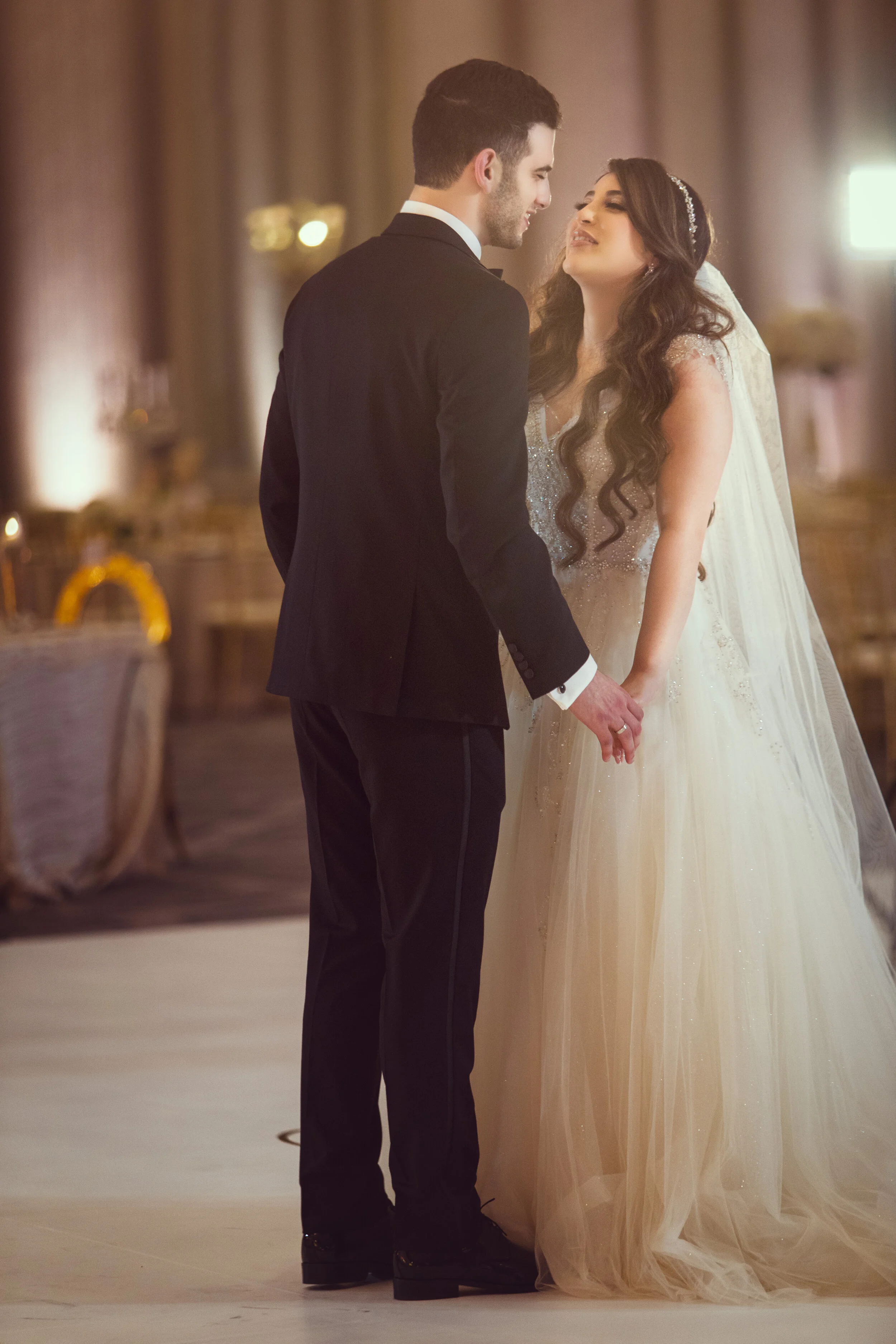 Bride and groom holding hands on a dance floor