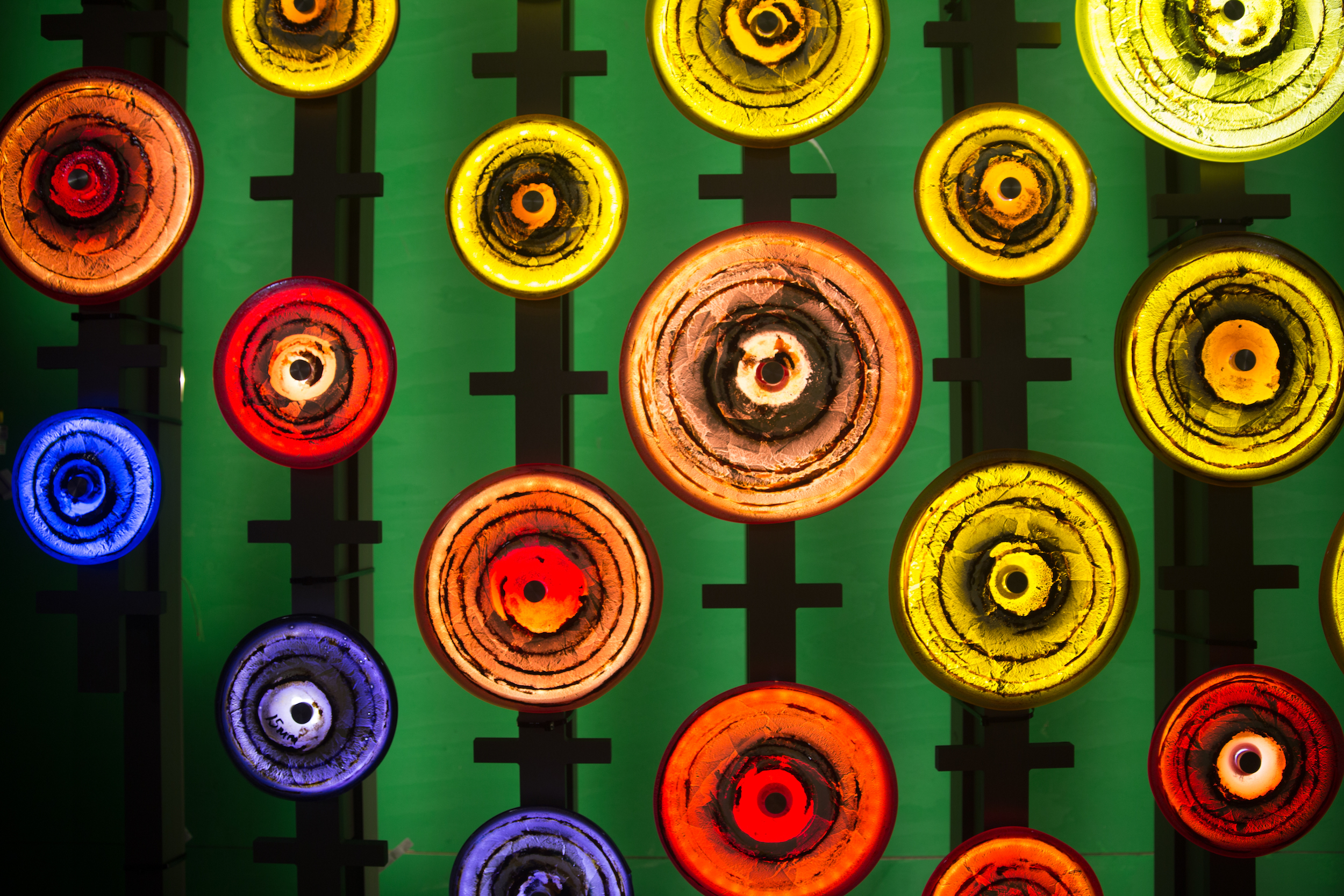 The scrolls depicted in handblown glass, with the portcullis frame behind. Together they form the Venus symbol of women. 