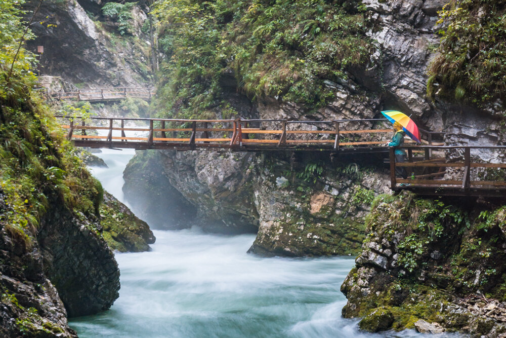 At the end of the gorge in Slovenia, a suspension bridge hangs above the 40-foot tall Sum Waterfall