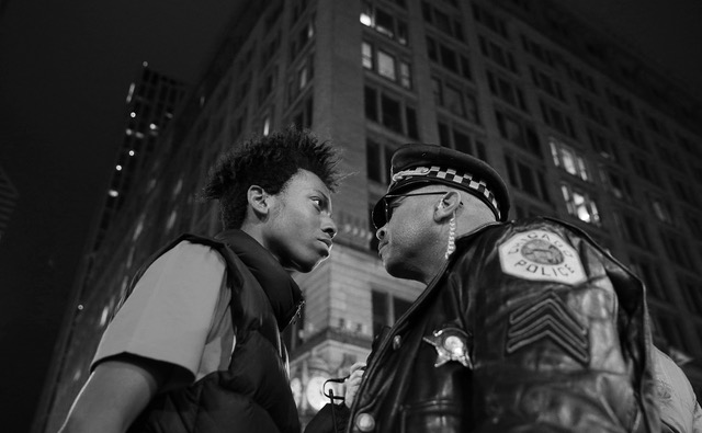 The 16-year-old activist Lamon Reccord stirs one police officer during a protest in Chicago on Nov. 25. 2015 against the fatal shooting of the 17-year-old Laquan McDonald the year before. Photo: John J. Kim / Chicago Tribune