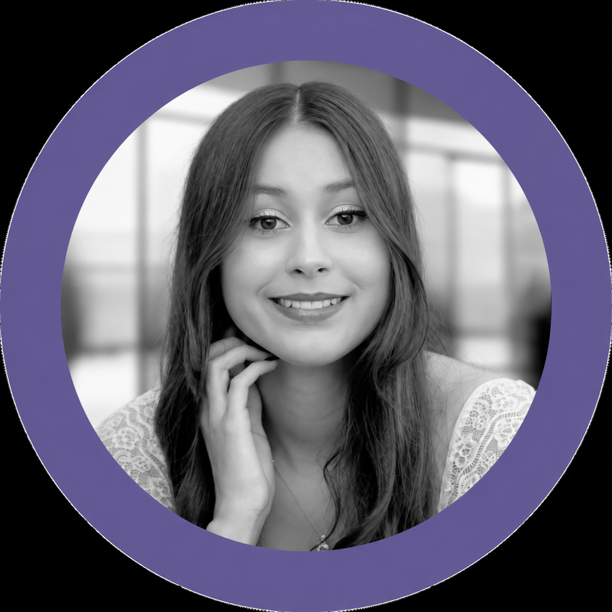 A young woman with long wavy hair, smiling, wearing a lace top, in a black and white photo with a purple circle border.