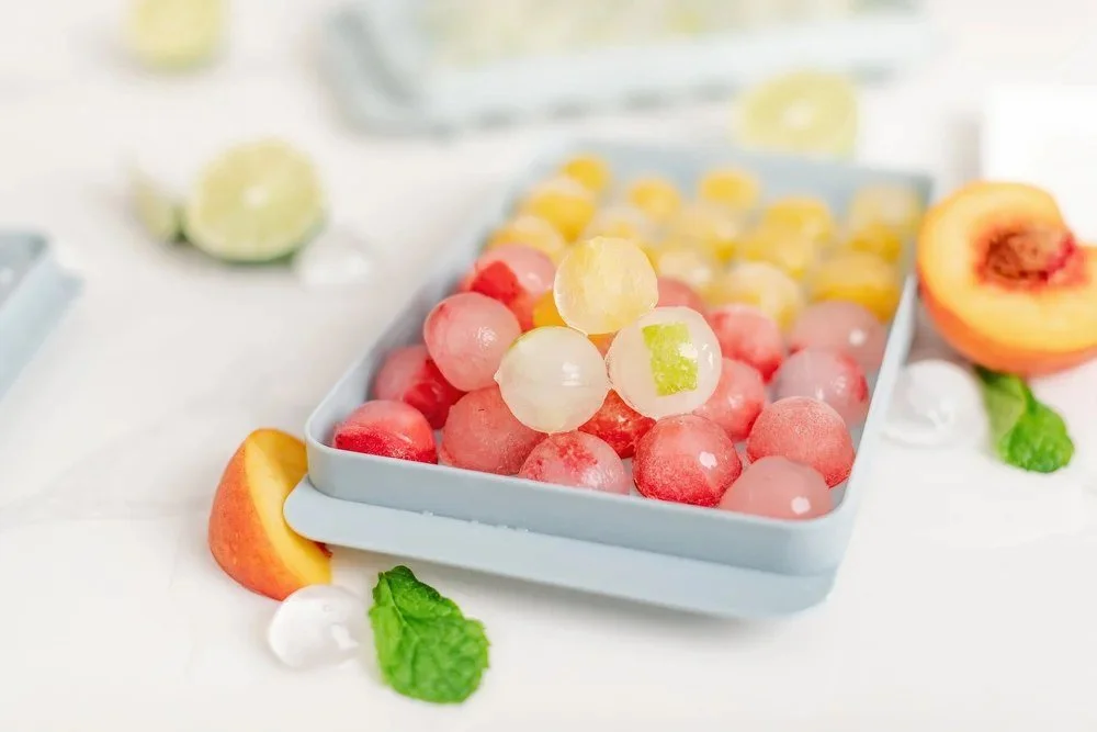 Colorful fruit candies with peach, citrus, and mint in a blue tray.