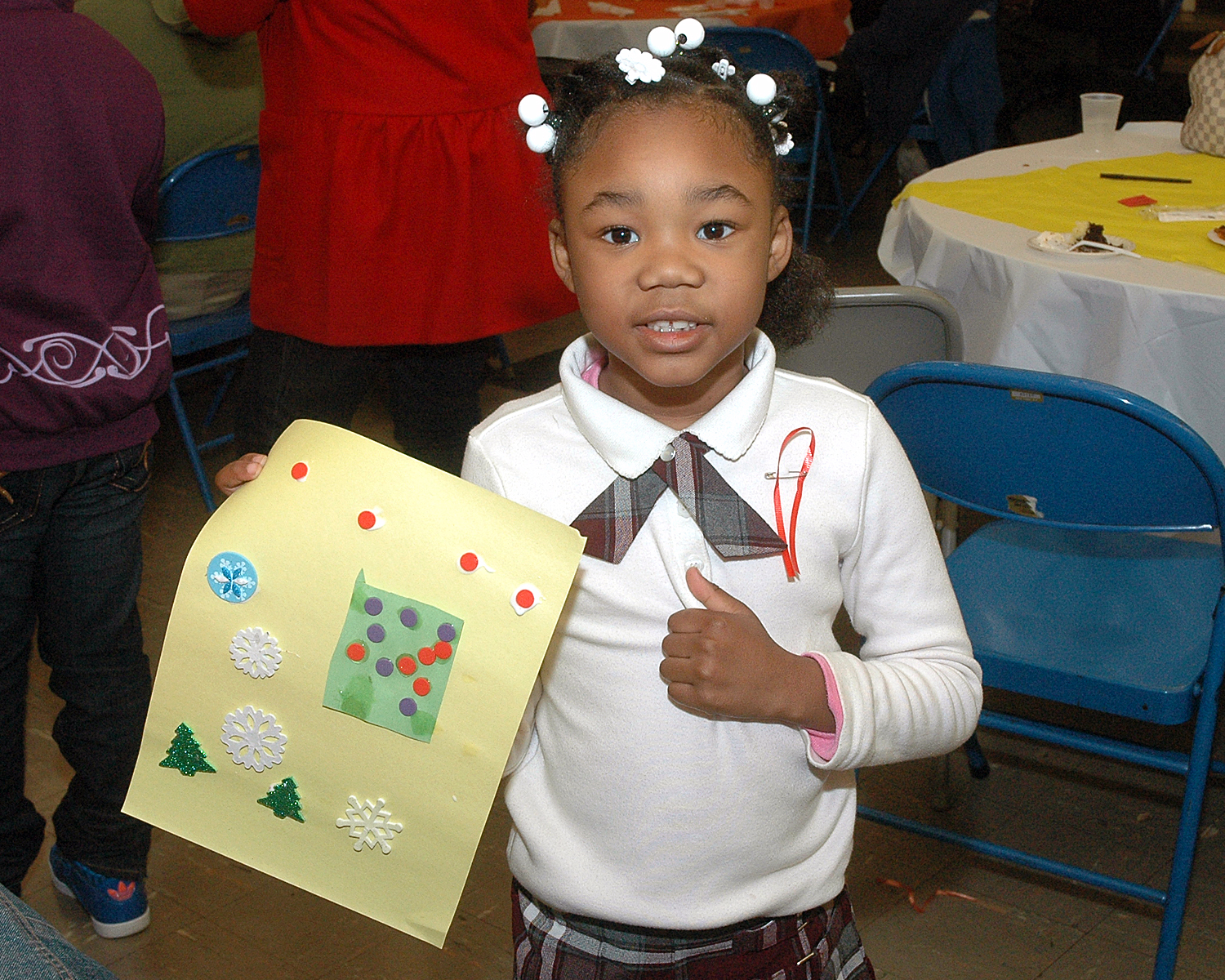 An attendee proud of the artwork that she created at Kids Korner