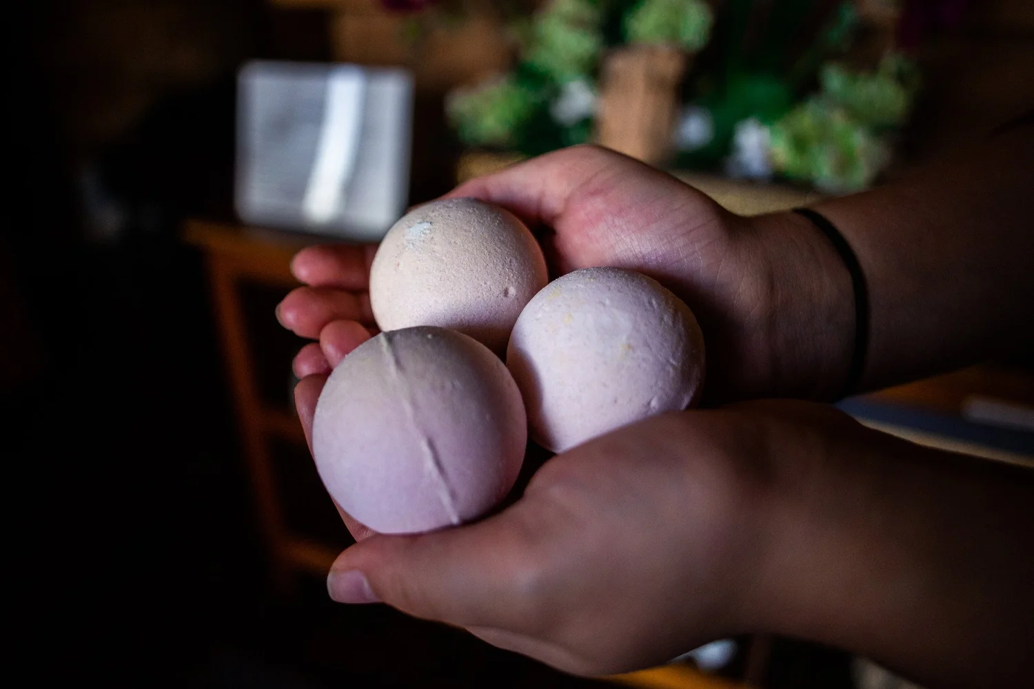 Three pale bath balls held in cupped hands