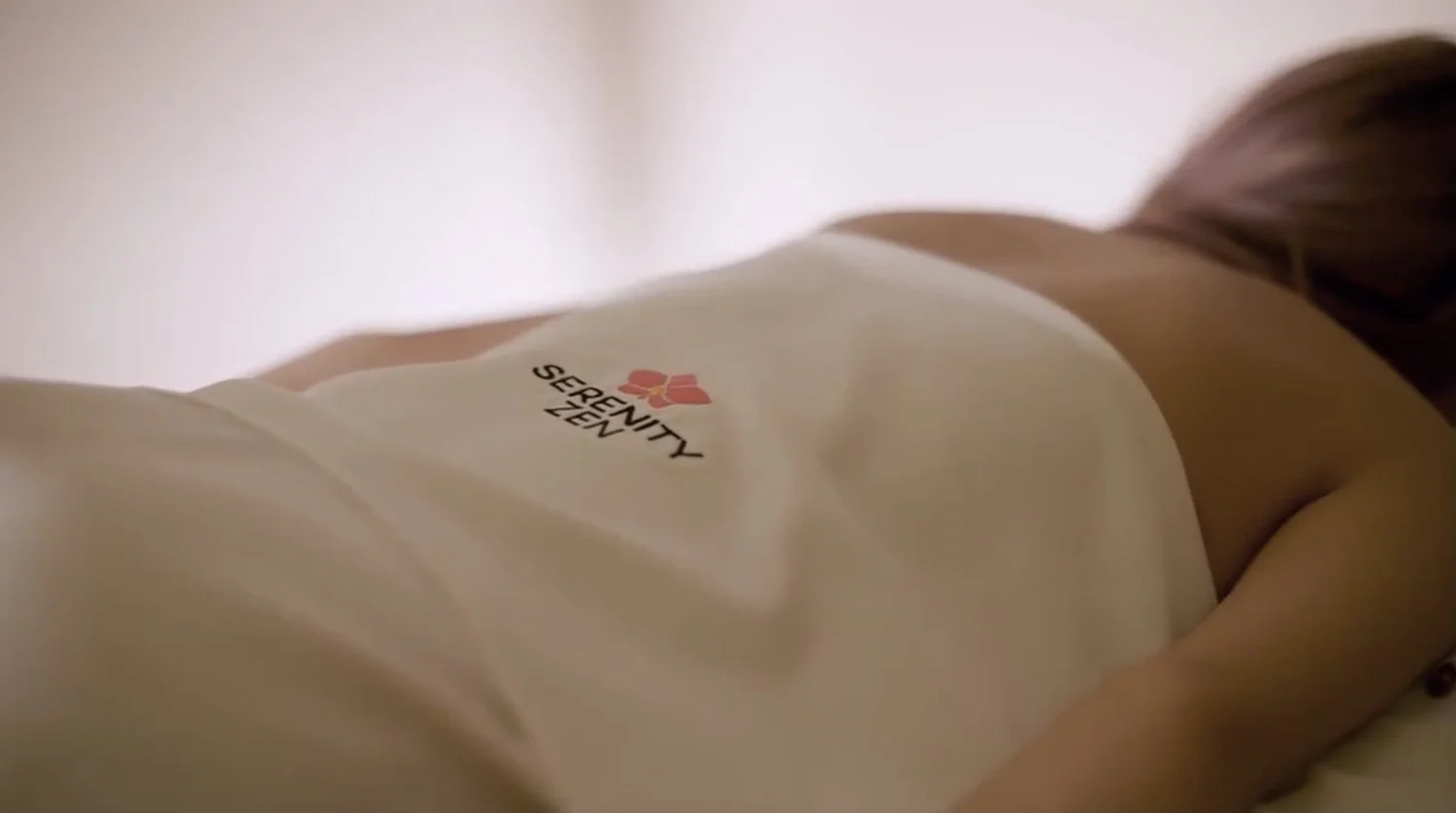 A guest lying face down, draped in a Serenity Zen sheet