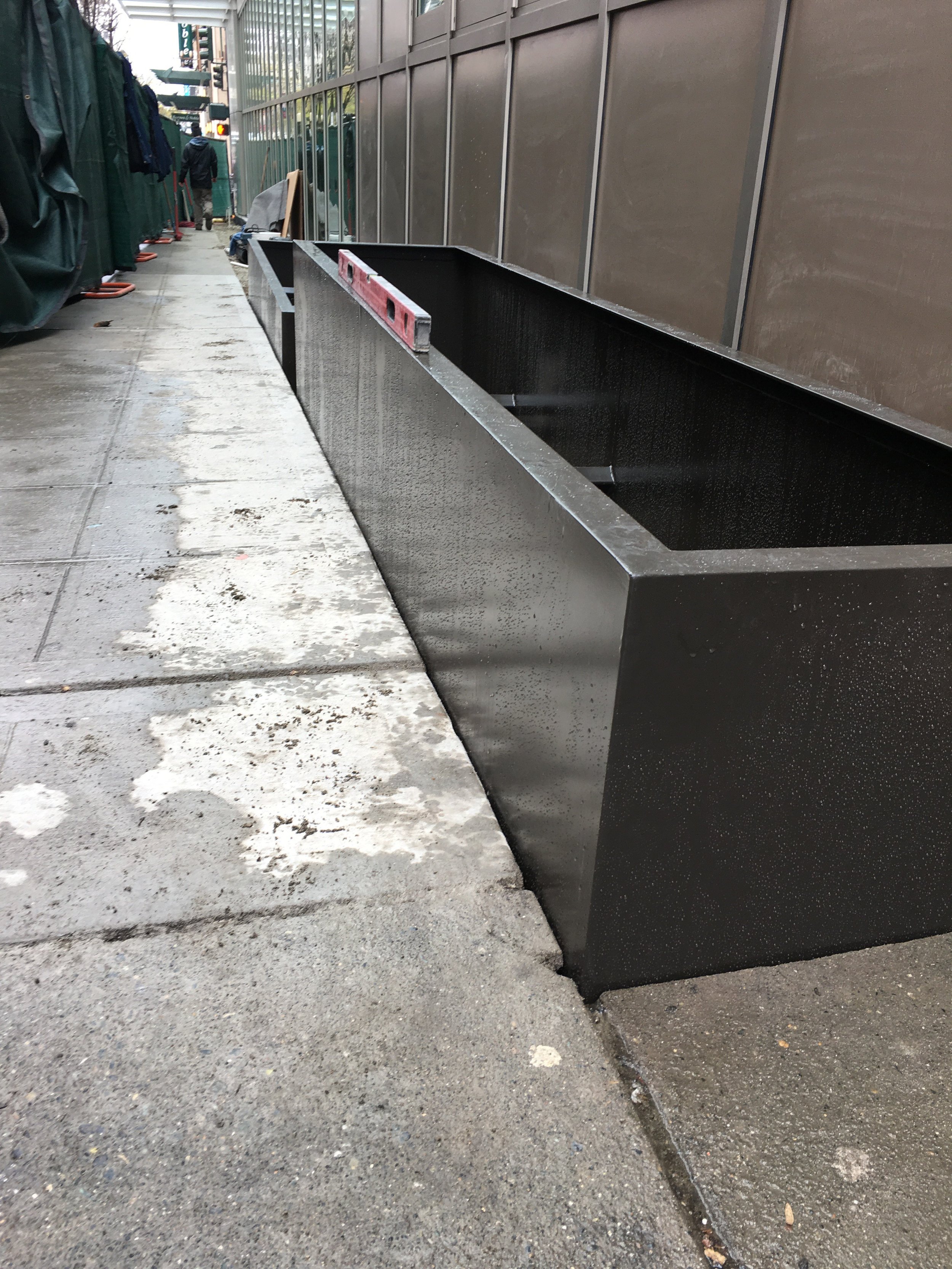 Installing streetscape planters with adjustable leveling feet.