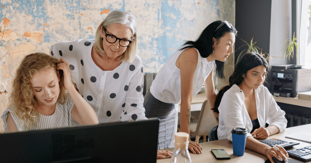 Coworkers reviewing catering options and reading online ratings on a laptop before placing an order