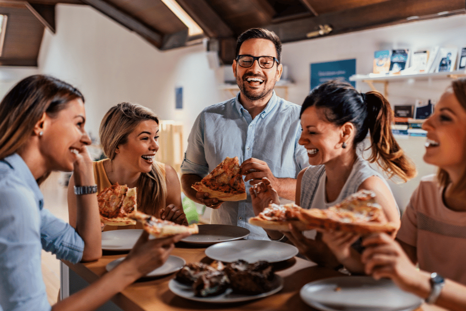 Happy office workers in Boston sharing a catered lunch together around a conference table