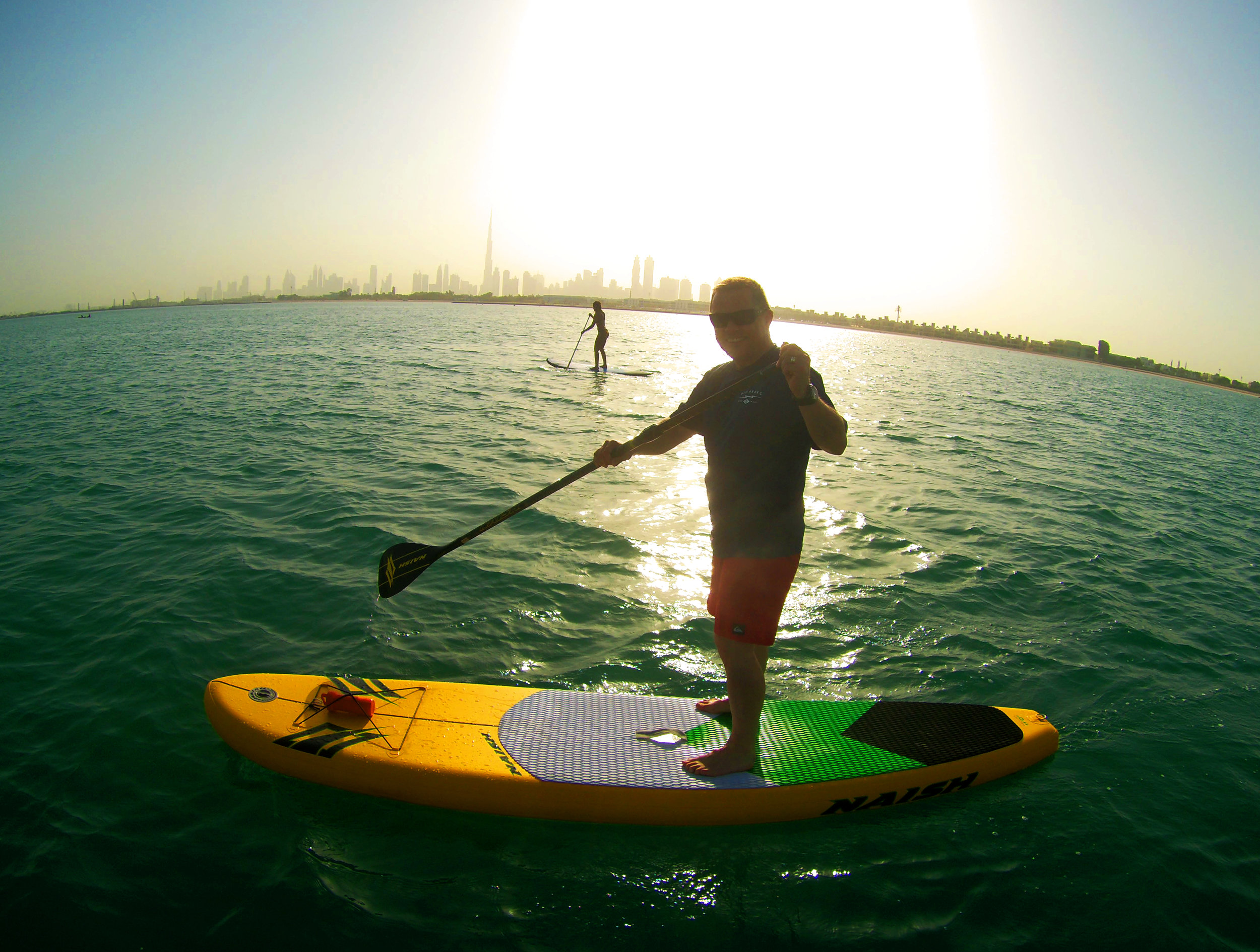 Toby on the SUP with girl in background.jpg