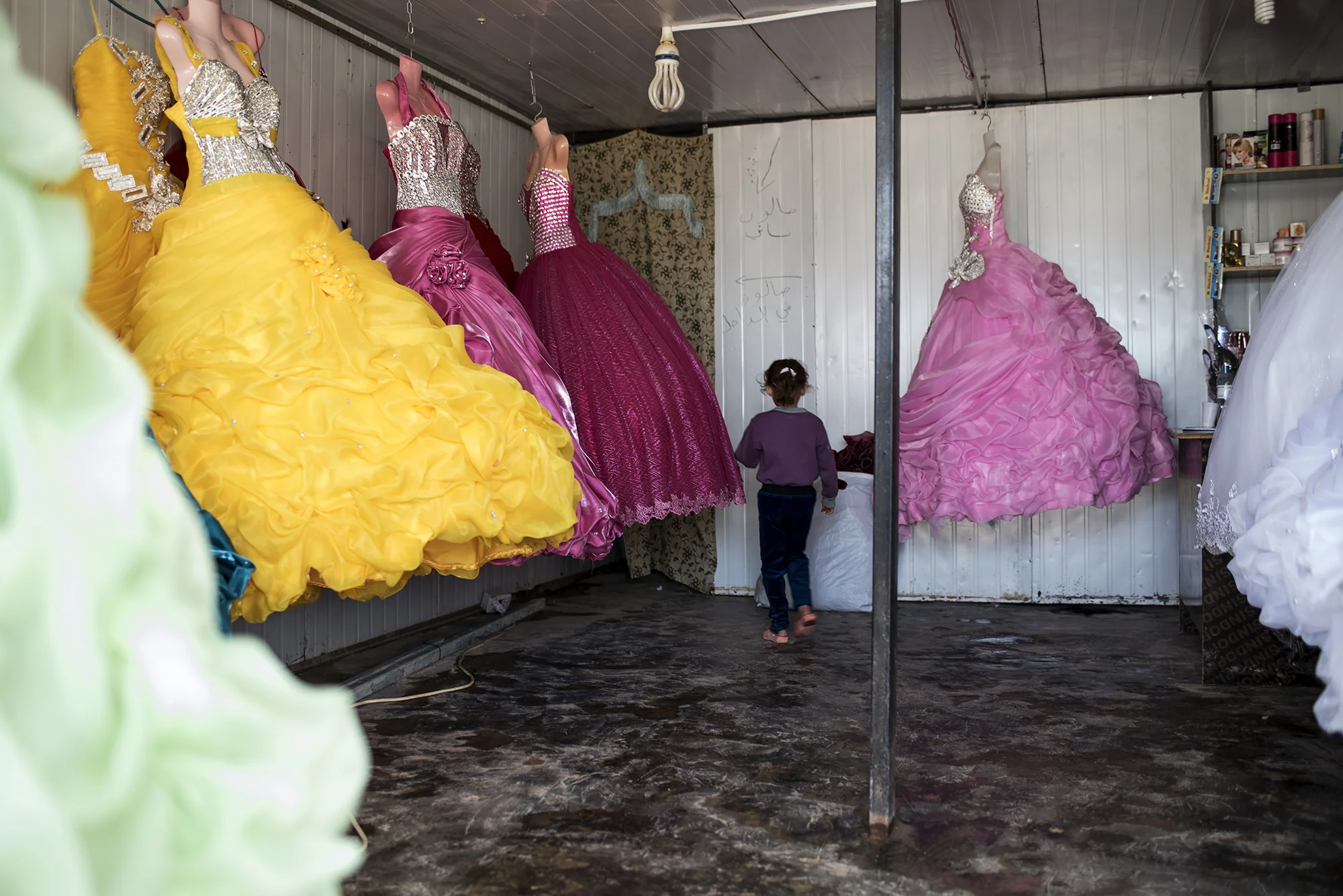 A child walks through a wedding dress shop in the central market of Jordan's Zaatari refugee camp, October 2015.
