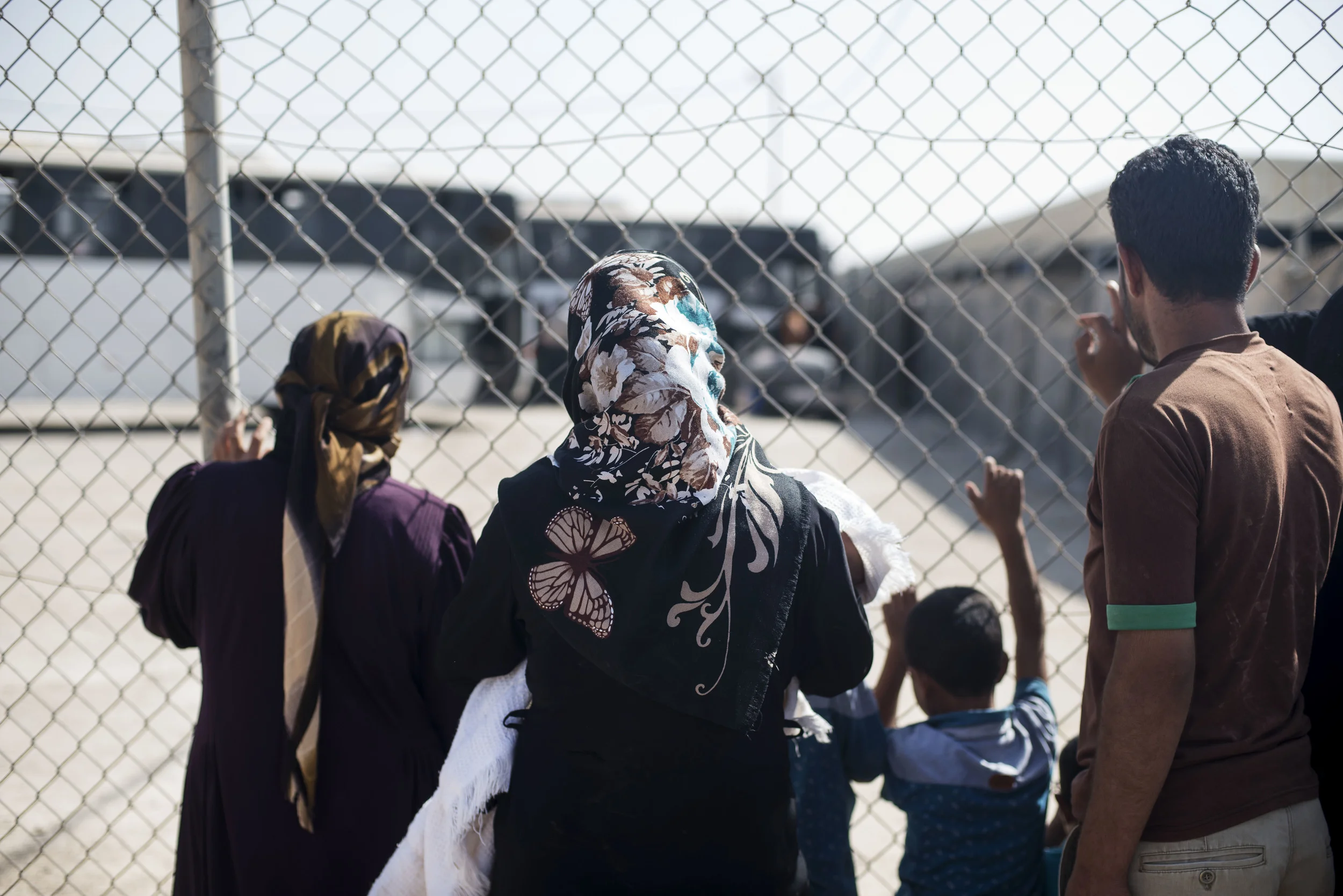 Zaatari camp residents watch as family members load onto buses headed out of the camp and back to Syria. October 2015. 