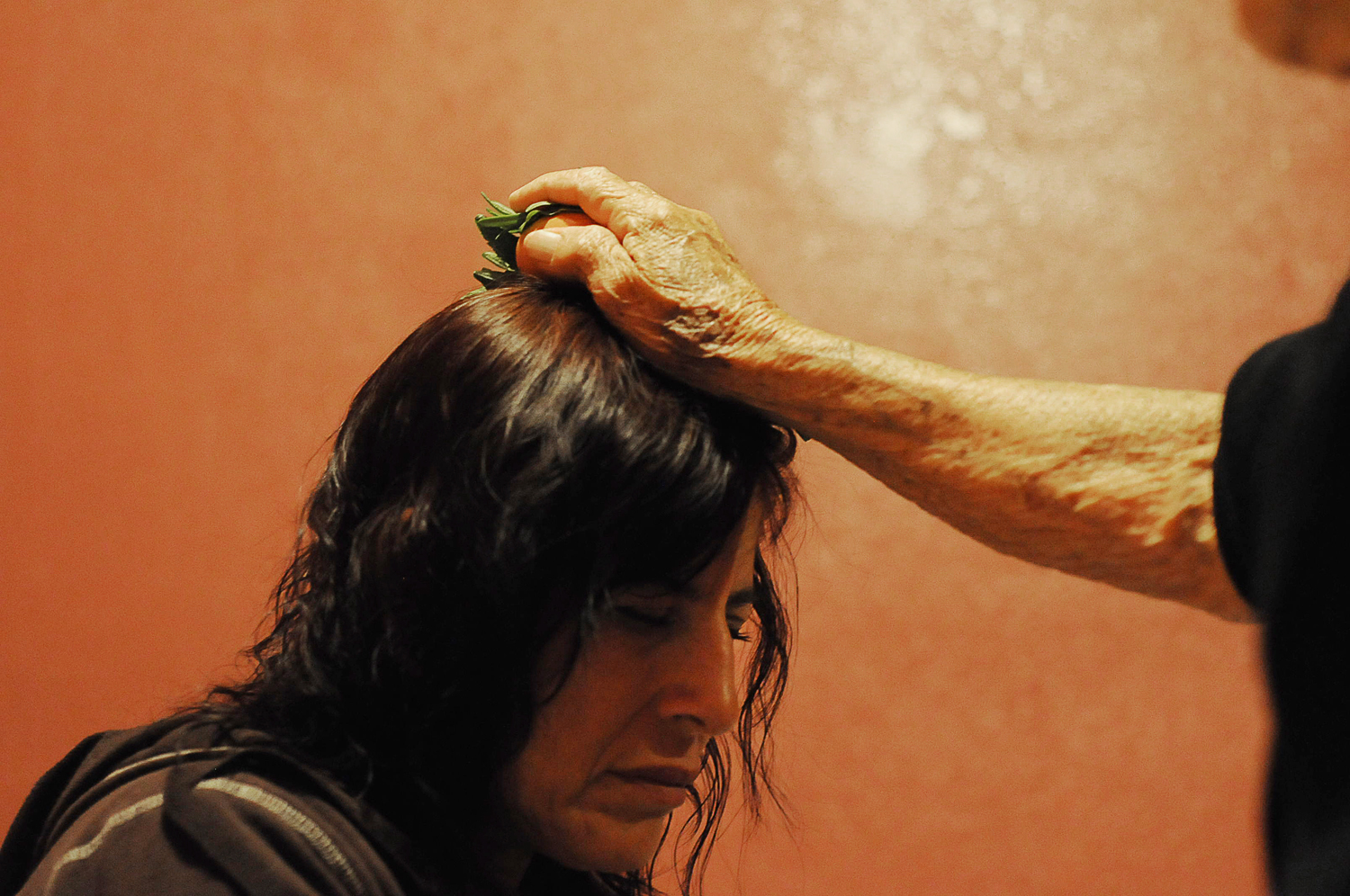 Louse Davilla, 42, receives a cleansing ritual treatment from her mother, Esther, in her home in Burlington, Washington. The farming community is home to several generations of Mexican immigrants, but Esther's practice of traditional Mexican healing, or Curanderismo, is disappearing in the US. See the full story at NPR's partner station, KUOW. September 2013.