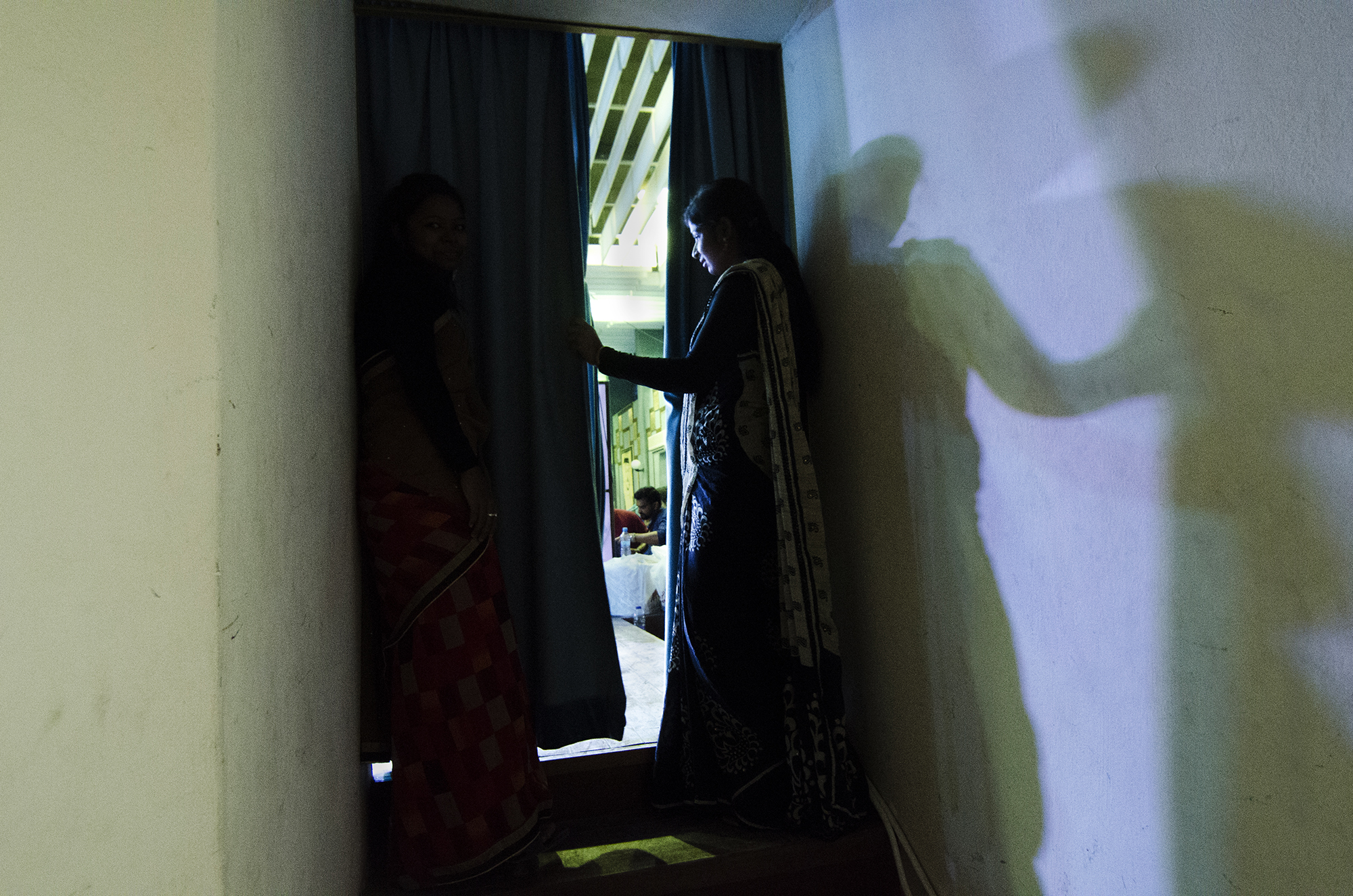 An Indian performer looks on from backstage.