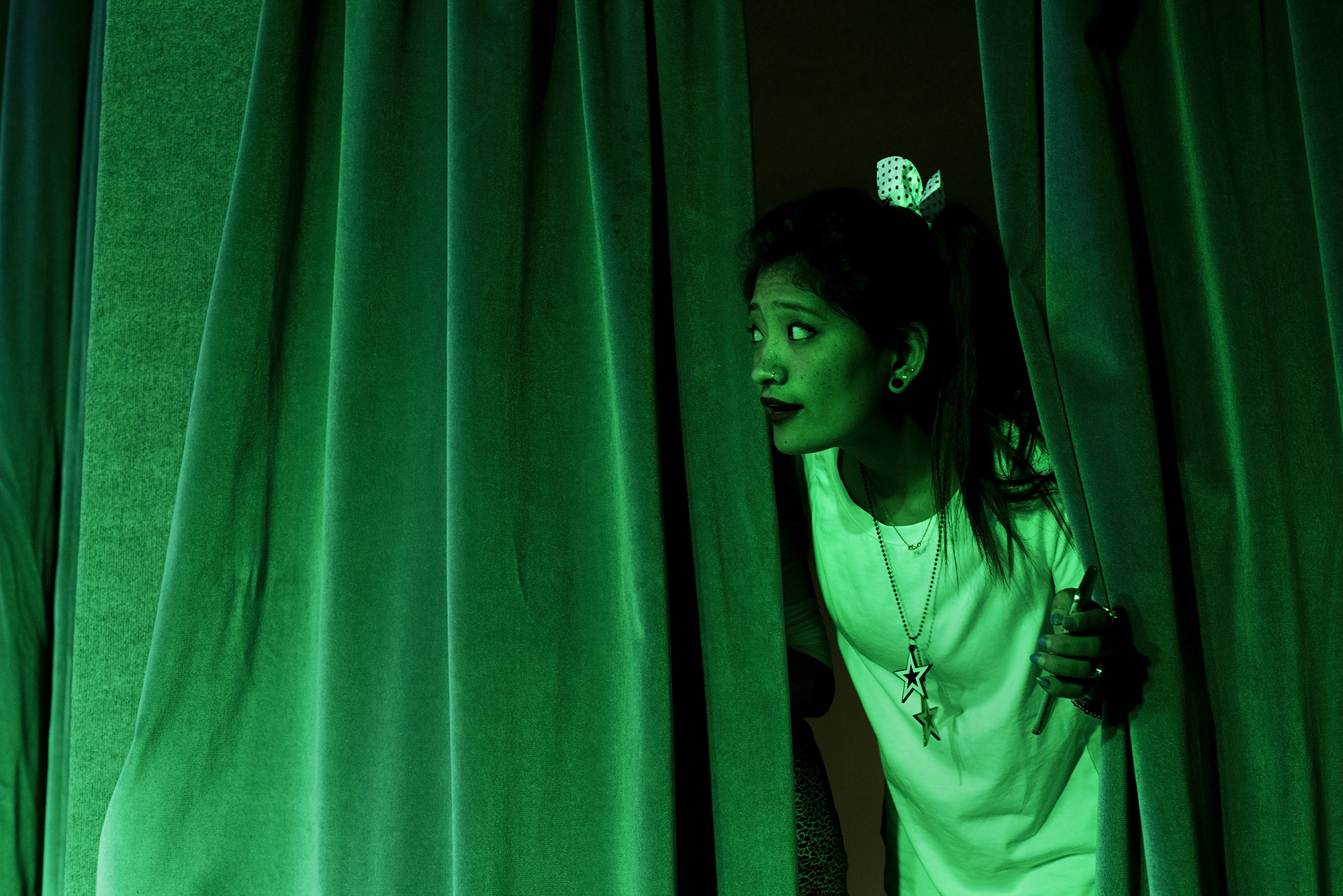 A Nepalese worker looks out from backstage.