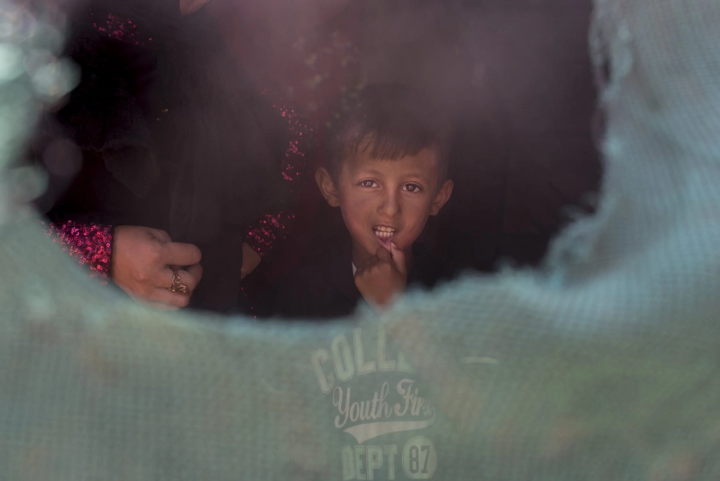 A Syrian child looks out from his family's tent in an informal tent settlement near the northern Jordanian city of Mafraq. July 2015.