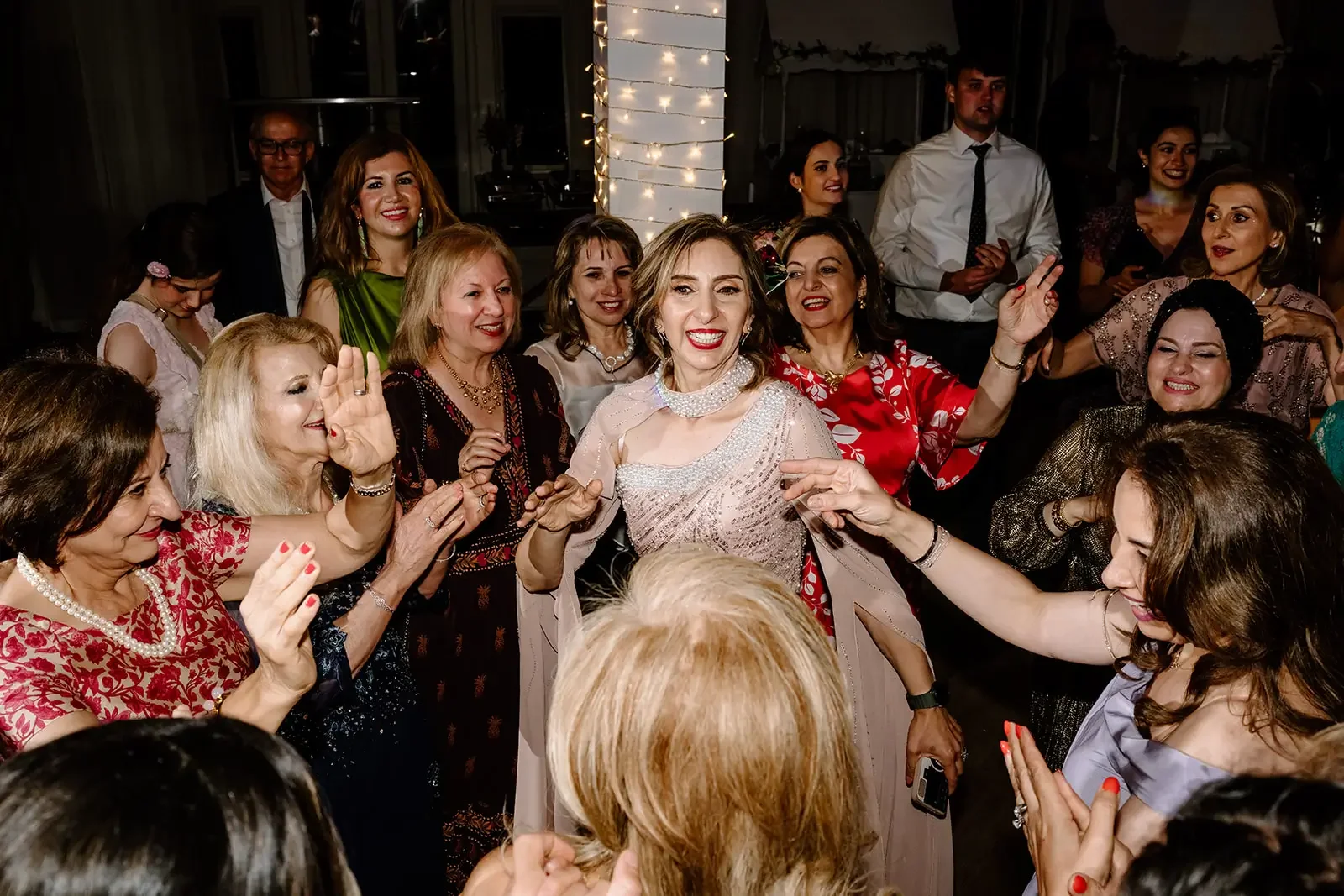 Group of women dancing and celebrating at a party, with smiles and joyful expressions.