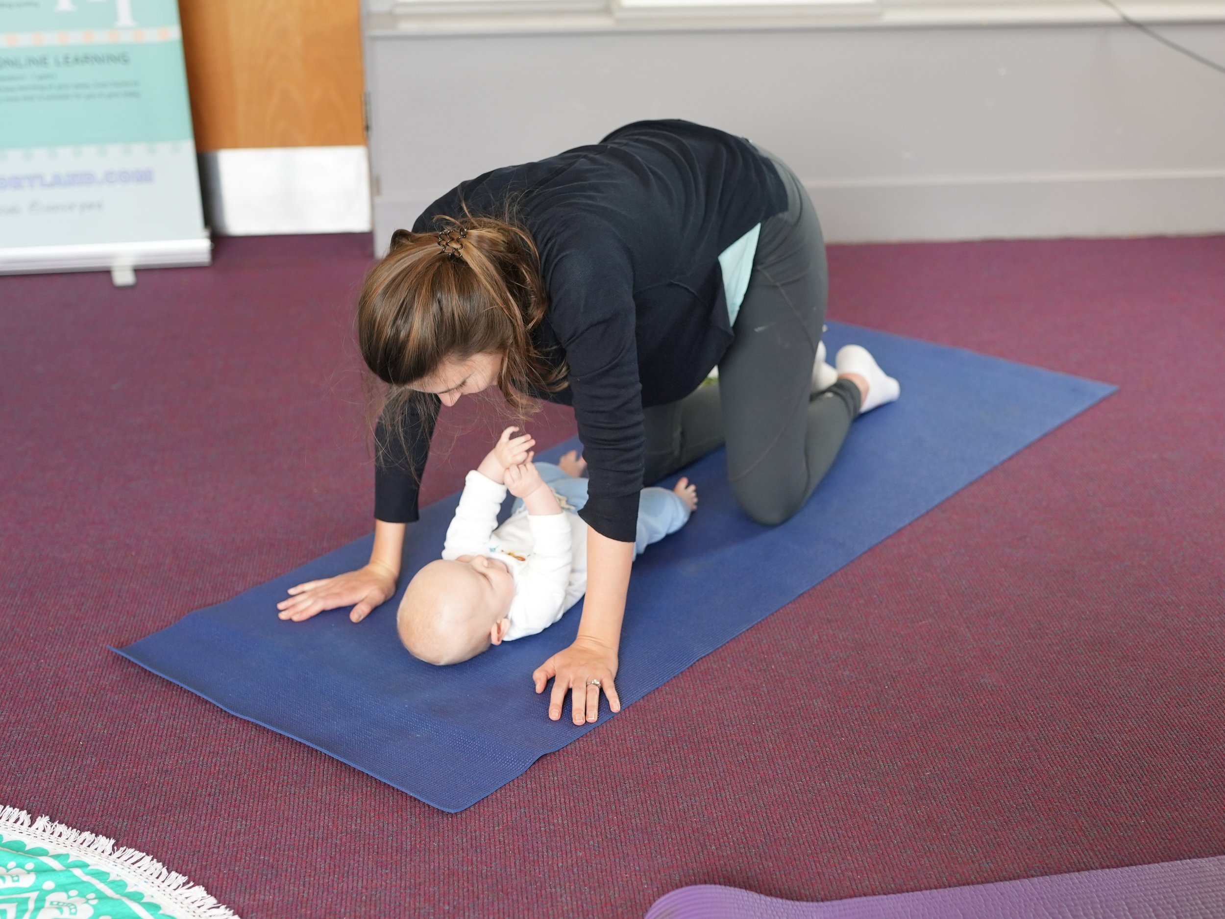  Mum is in a table top position on all fours over her baby so she is able to look down at him 