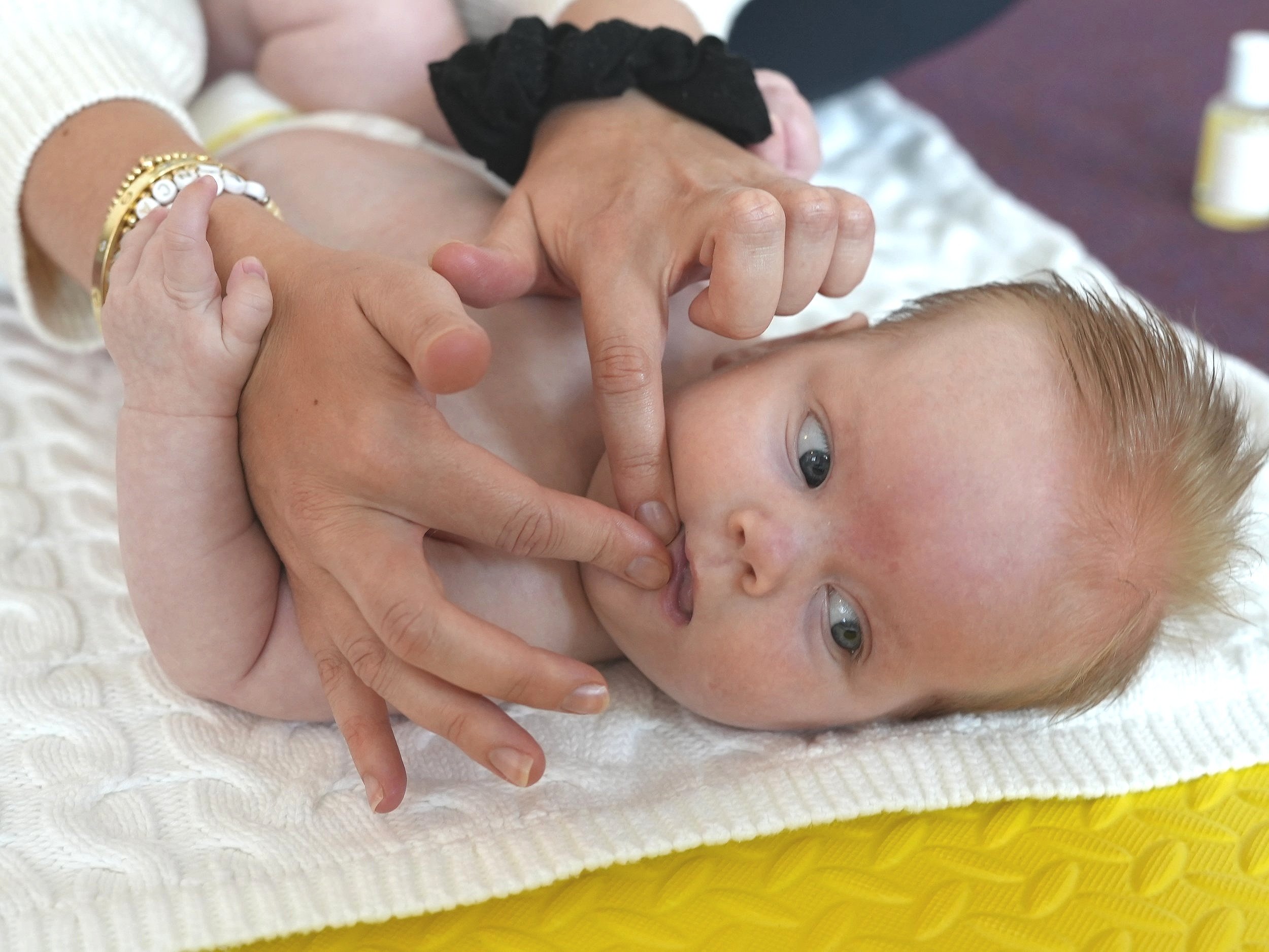  Baby is getting her gums massaged by her mum 