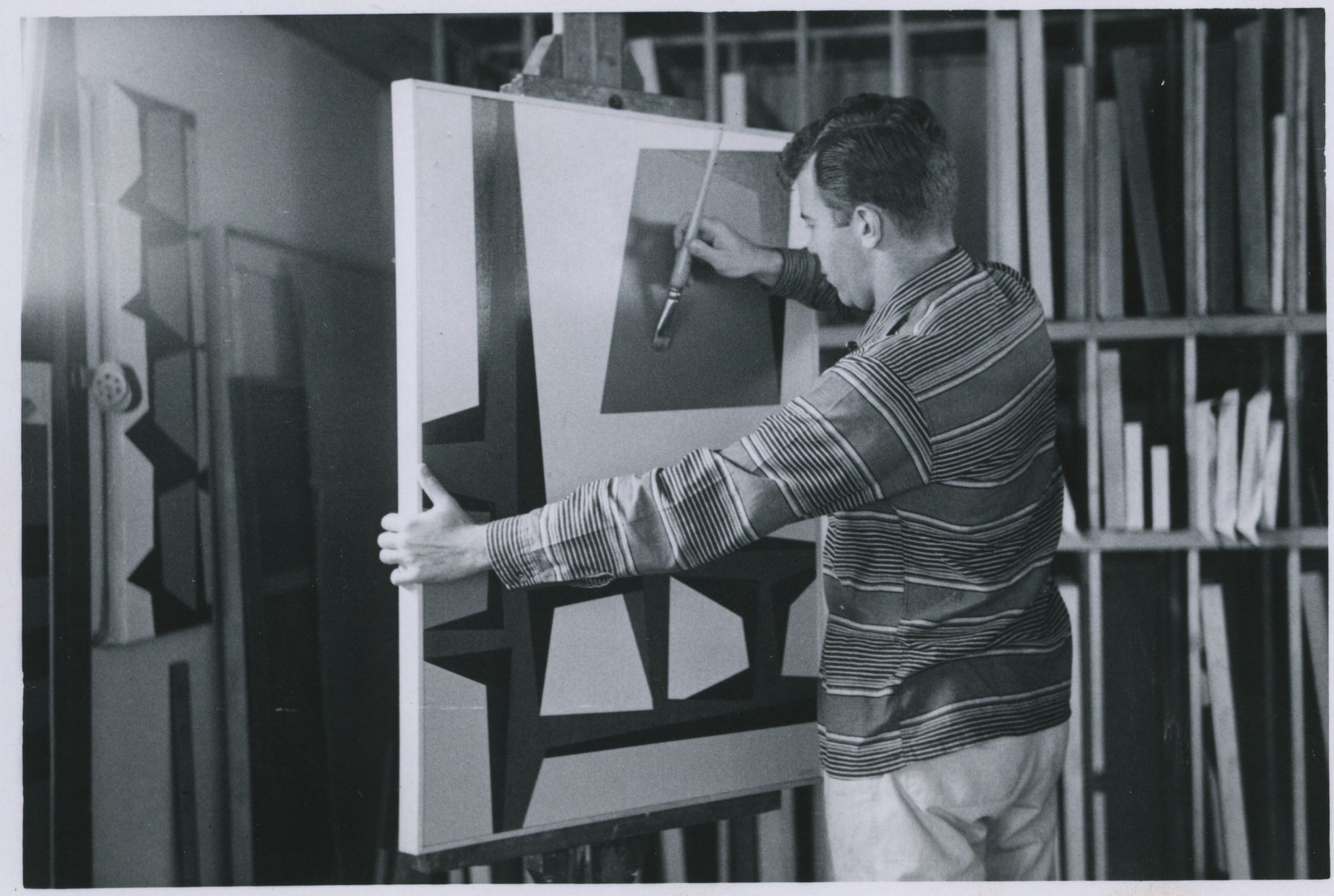 Karl Benjamin in his studio, painting "Green Moon with WIndows," 1957.
