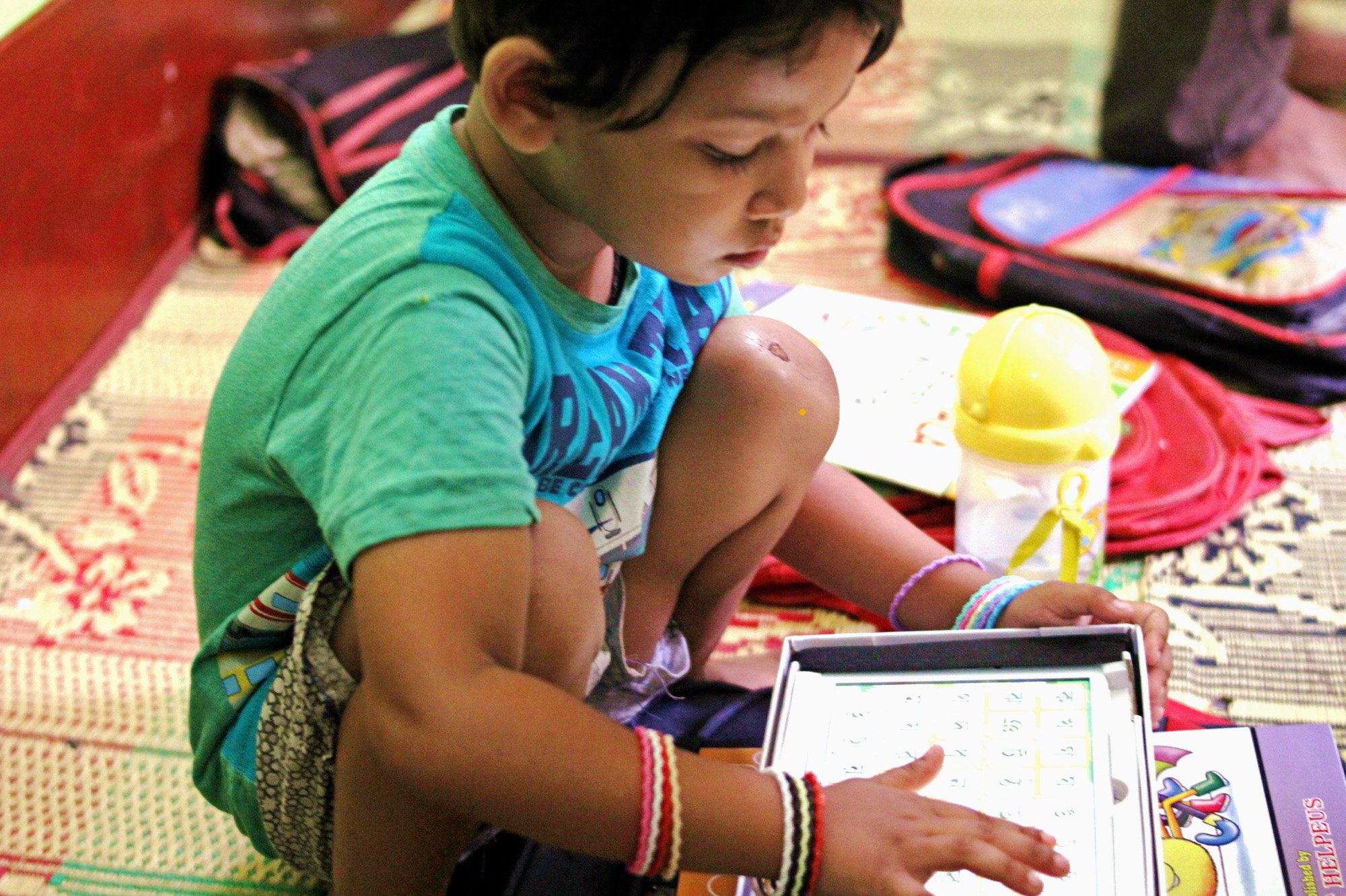 This young student is learning the Bangla alphabet.