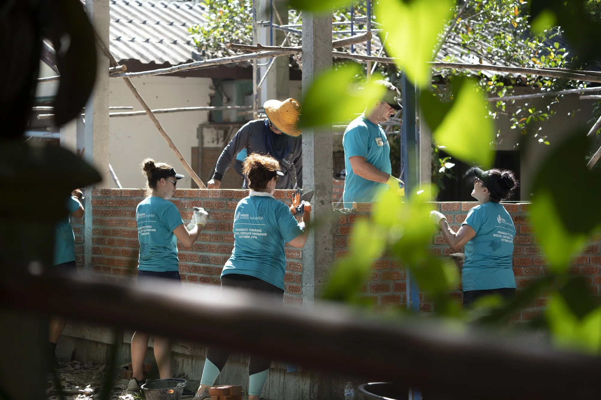 Participants in the Social Venture Program working together to lay bricks and build a kitchen