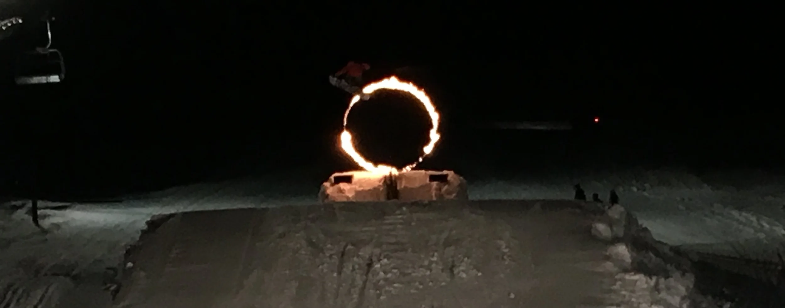Snowboarder flying through the ring of fire