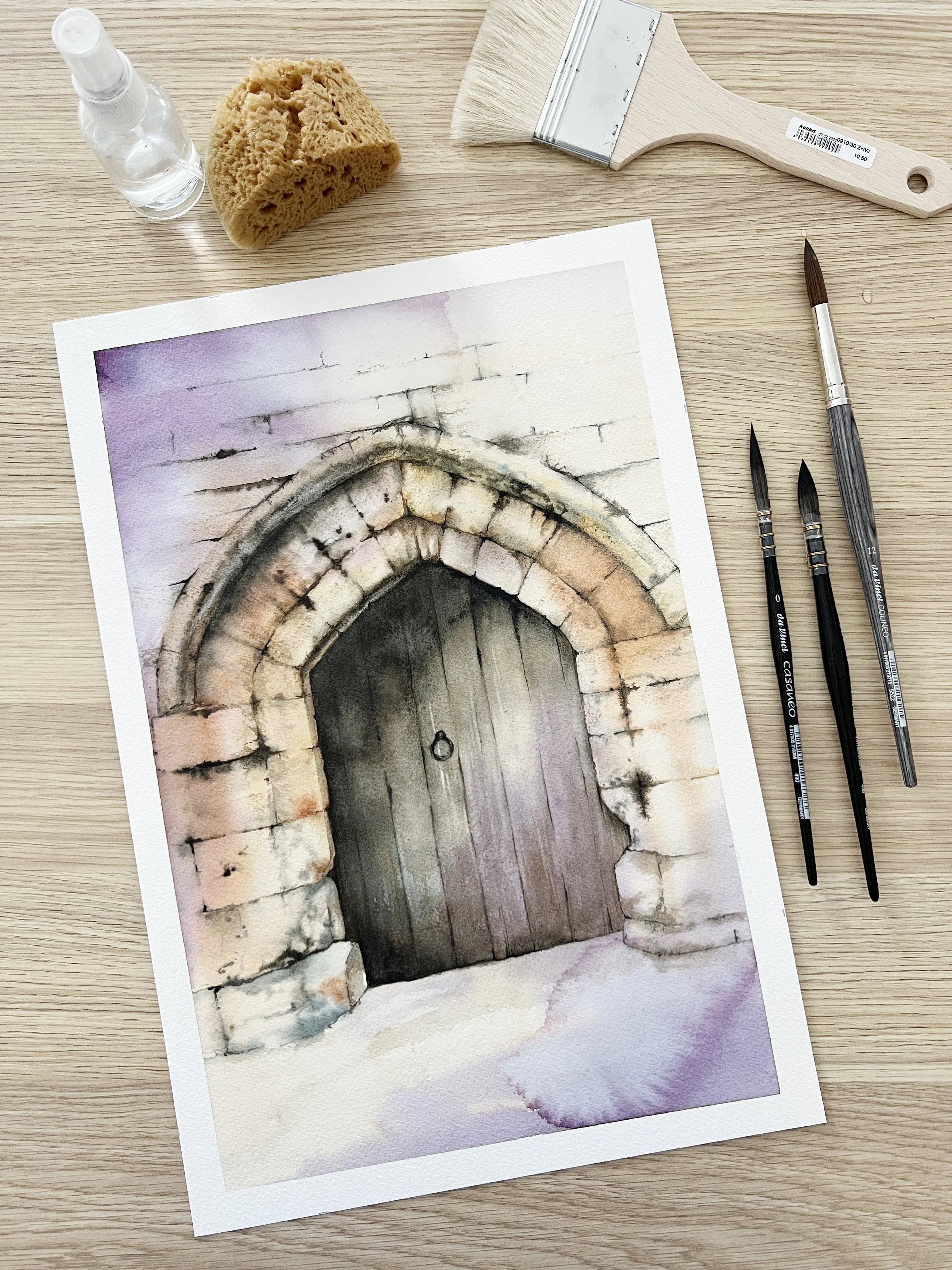 Finished watercolour painting of an old stone arch doorway with textured bricks and wooden door.