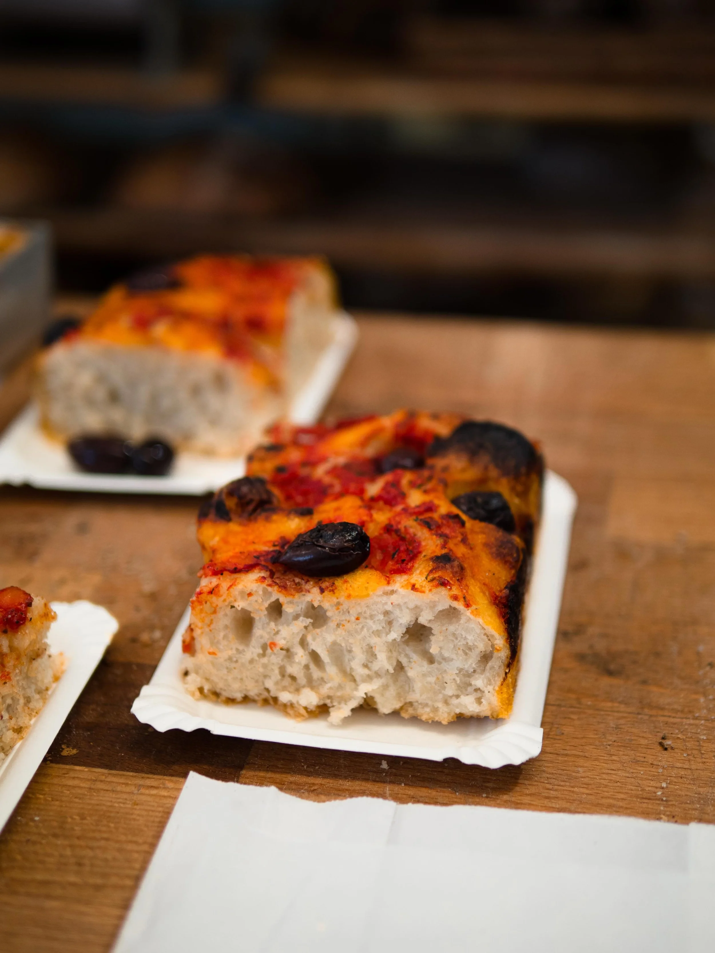 Je klassischer, desto besser.

Unsere Focaccia mit Tomatenpolpa und Oliven backen wir in Moabit und in der Uhlandstra&szlig;e. Sie ist p&uuml;nktlich zur Mittagszeit fertig und kombiniert mit etwas S&uuml;&szlig;em &mdash; Zimtschnecke, Blechkuchen, 