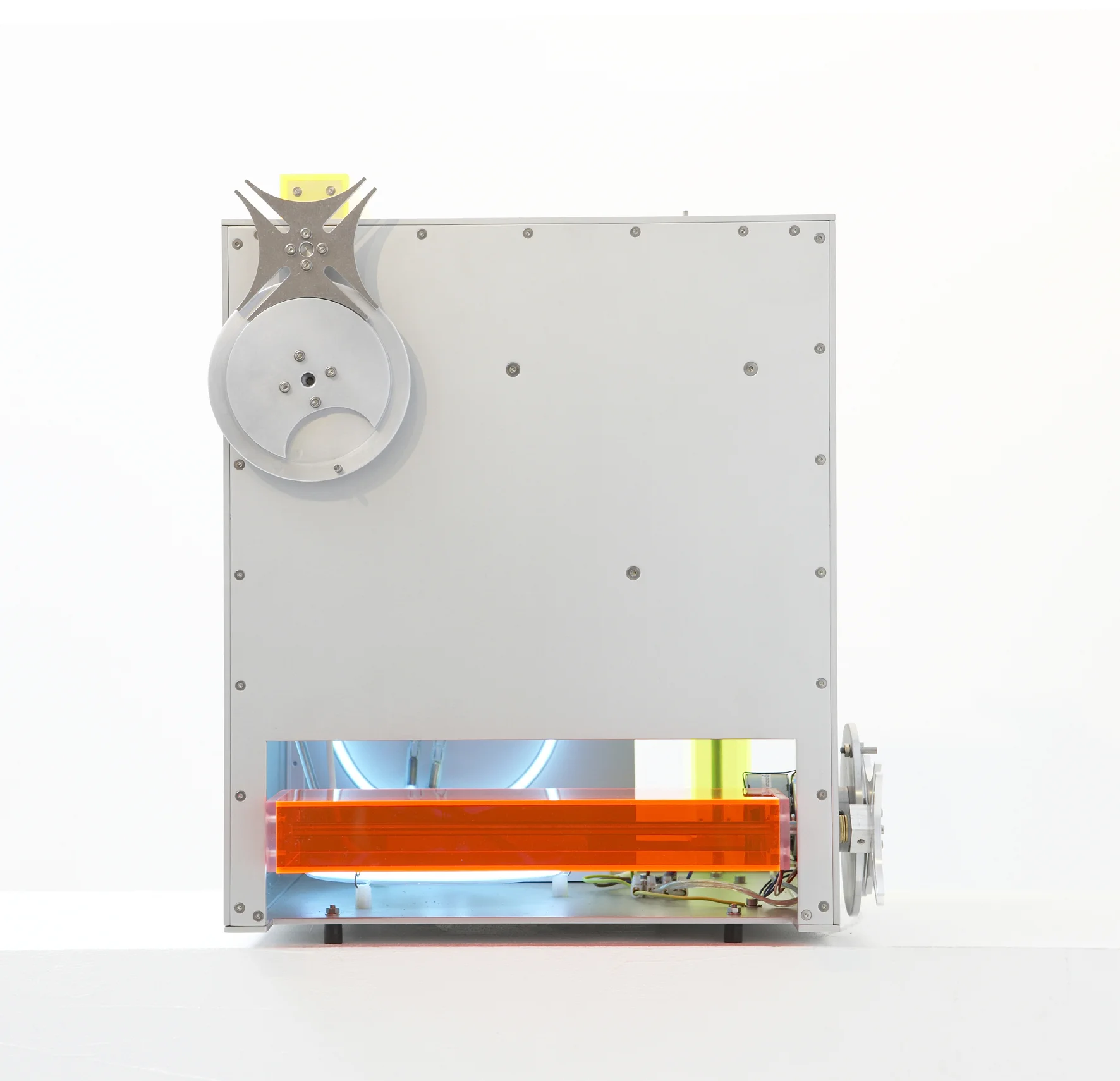 Bodenarbeit III, 2008, ca. 44x44x45 cm, Aluminium, farbiges Plexiglas, Neonsystem Blauentladung, 3 E-Motoren 4 U/min., 3 Malteserkreuzgetriebe