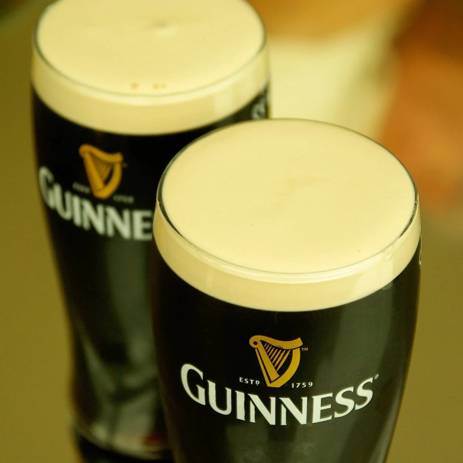 Two Guinness Draught pints in branded glassware
