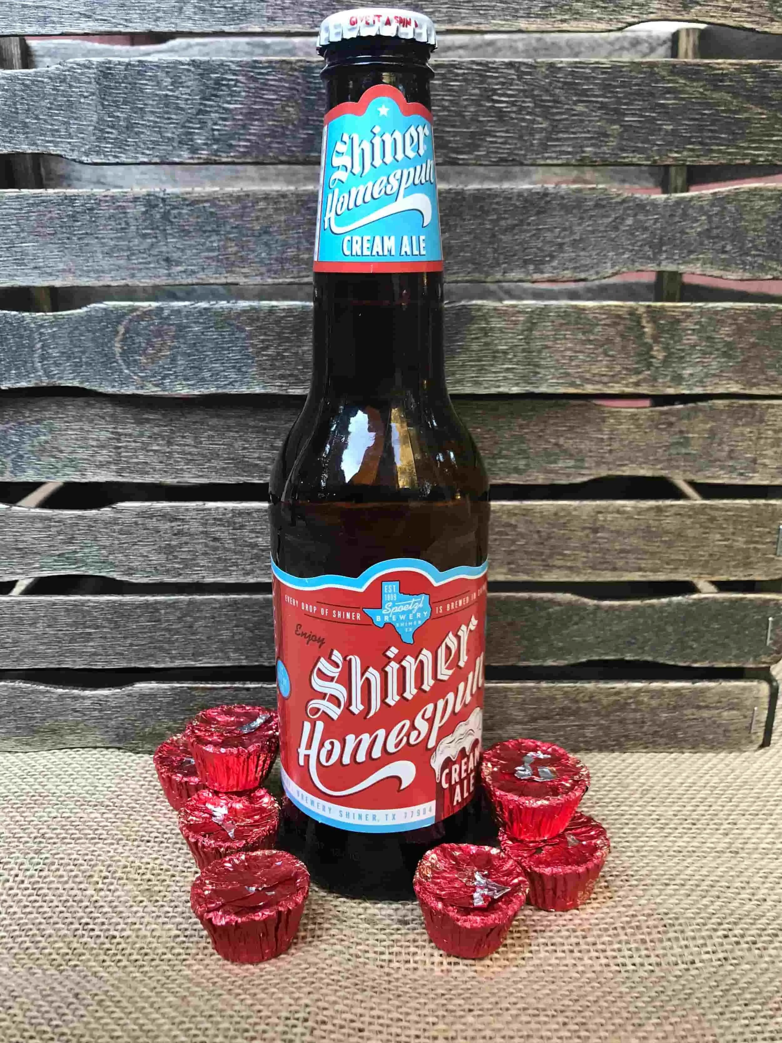 Shiner Homespun Cream Ale surrounded by red-wrapper Reese's Peanut Butter Cups
