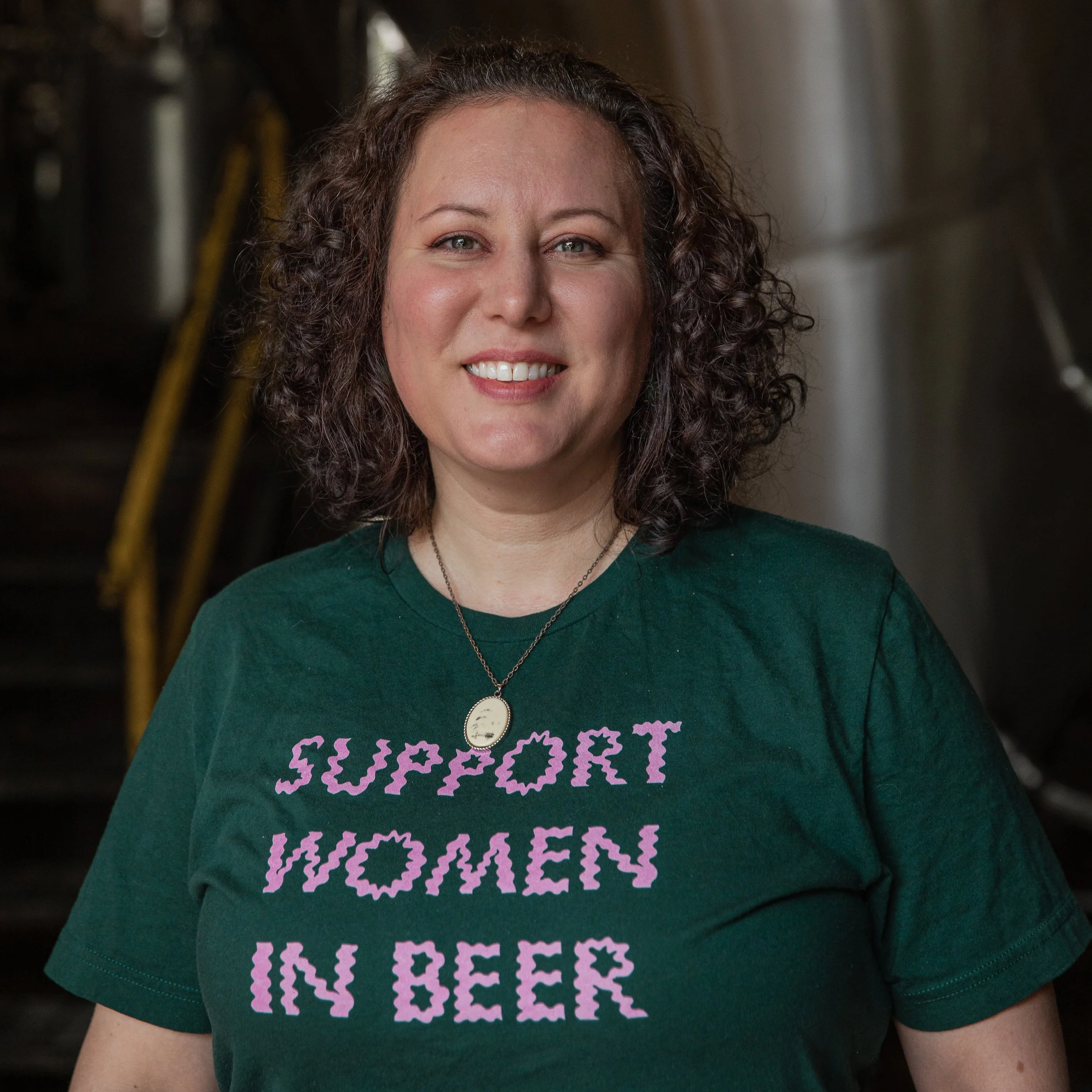 Jen Blair wearing green shirt that reads support women in beer in pink font
