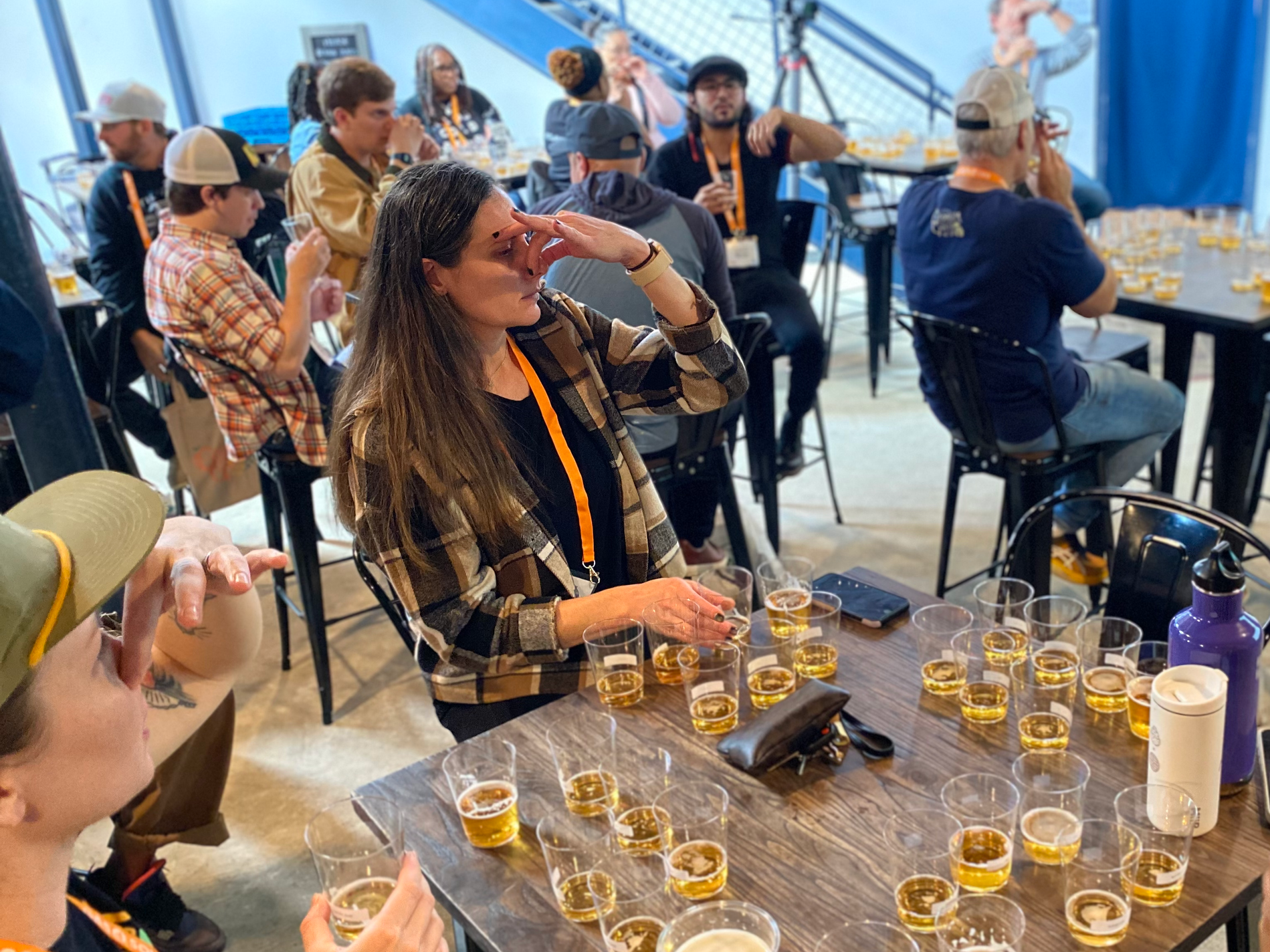 People pinching their noses with glasses of beer