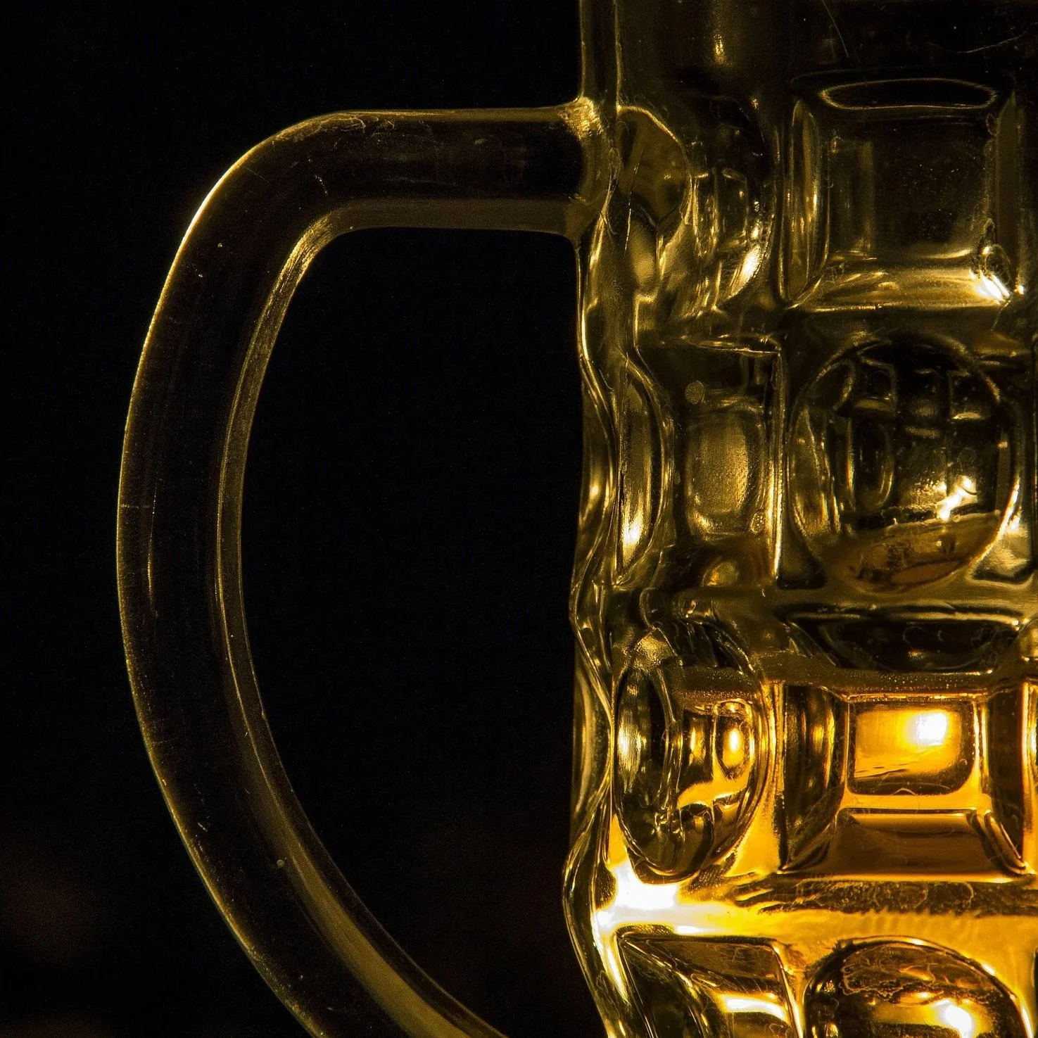 Close up dimpled mug with golden beer